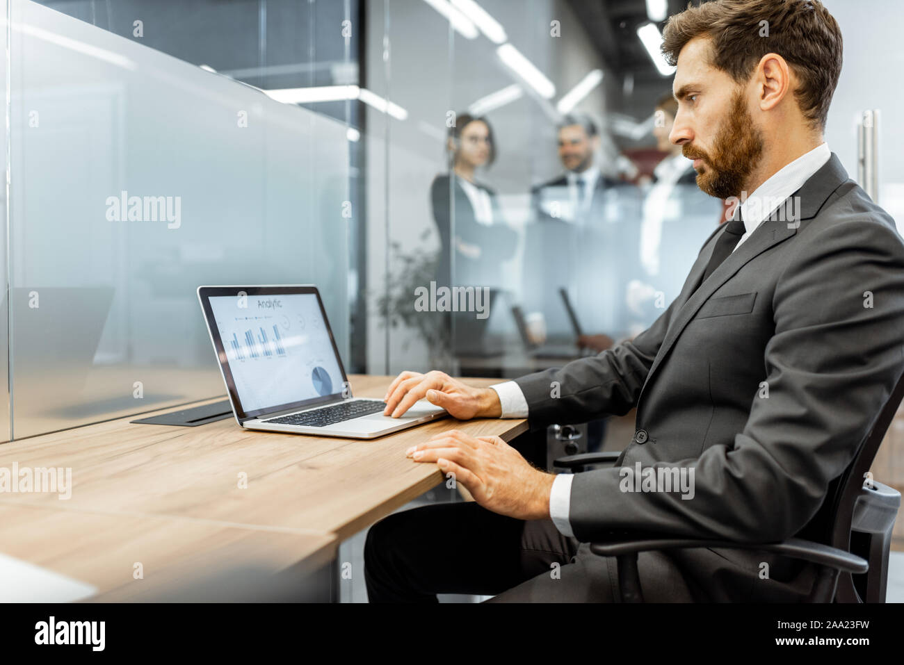 White-collar-Mitarbeiter arbeiten am Laptop am Arbeitsplatz in der Finanzabteilung eines großen Unternehmens Stockfoto