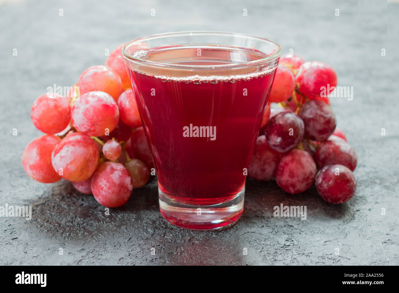 Glas Traubensaft und ein Zweig der Trauben. Close-up. Stockfoto