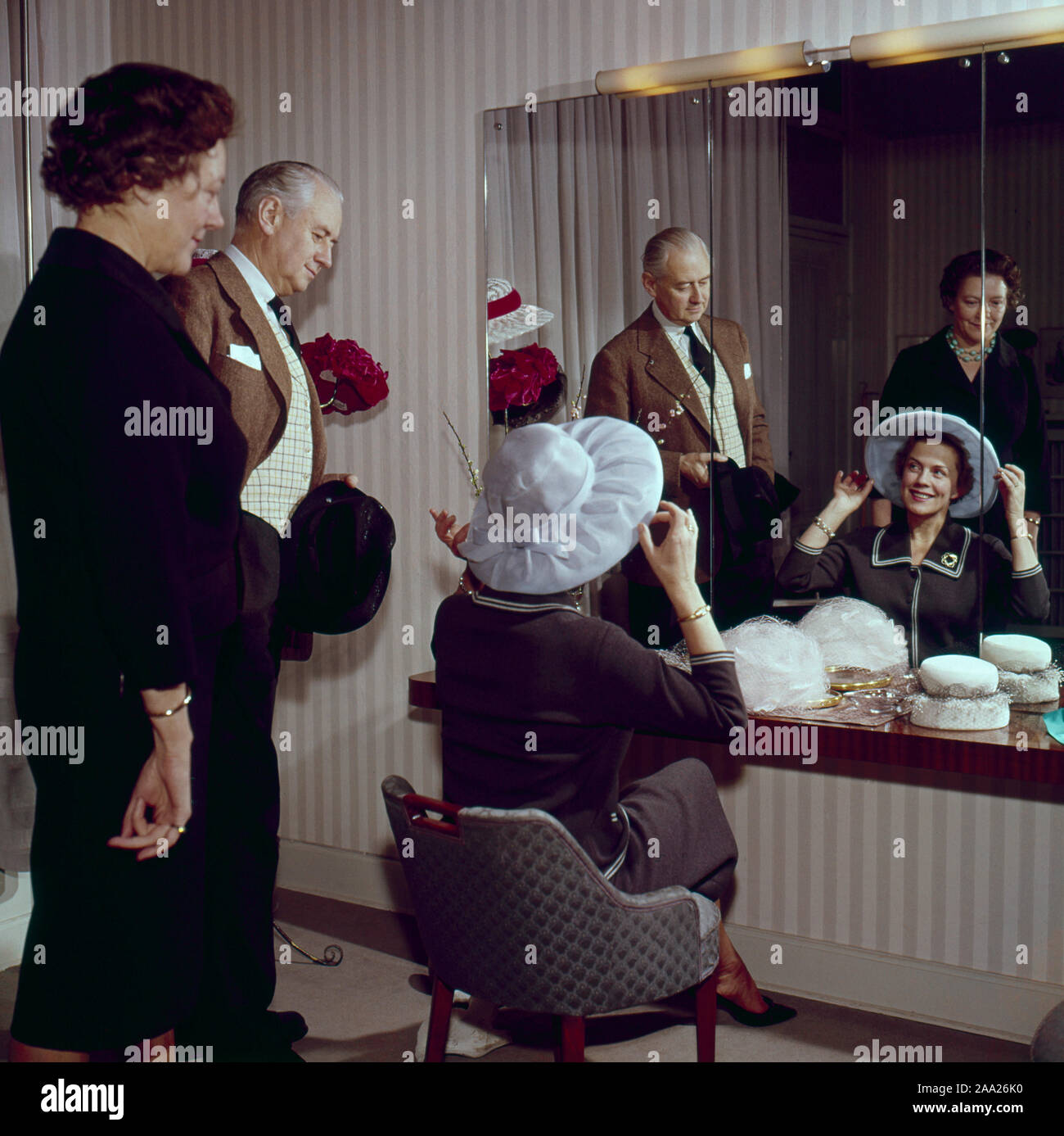 Sie versuchen, Hüte in den 1950er Jahren. Ein Paar sitzt vor einem Spiegel versuchen, Hüte auf. Er ist Humorist Erik Zetterström und sie ist Sickan Carlsson, Schauspielerin. Schweden 1950 Stockfoto