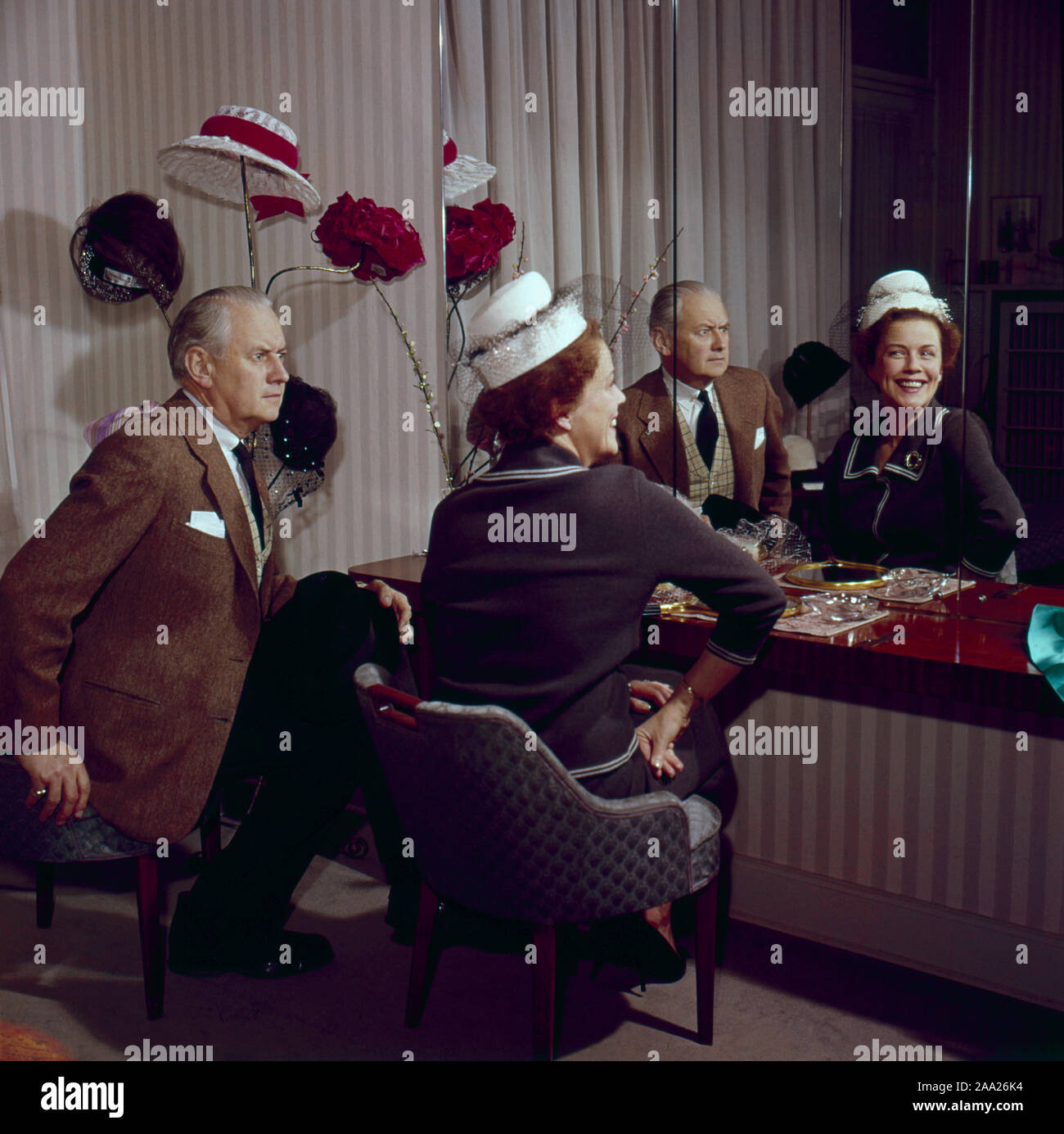 Sie versuchen, Hüte in den 1950er Jahren. Ein Paar sitzt vor einem Spiegel versuchen, Hüte auf. Er ist Humorist Erik Zetterström und sie ist Sickan Carlsson, Schauspielerin. Schweden 1950 Stockfoto