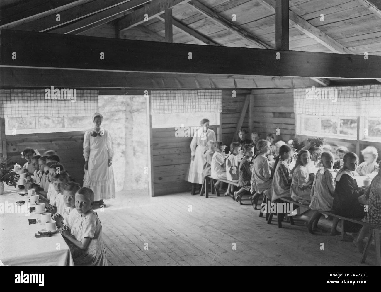 Kinder im Sommerurlaub 1918. Kinder, die in den Städten unter schlechten Umständen, und Eltern lebten, konnte es sich nicht leisten, in Urlaub gehen, könnte ohne Kosten für ein paar Wochen im Sommer an einen Kinder Sommer Camp in der Landschaft. Hier sind die Kinder beim Mittagessen in Barnens Ö nördlich von Stockholm 1918. Stockfoto