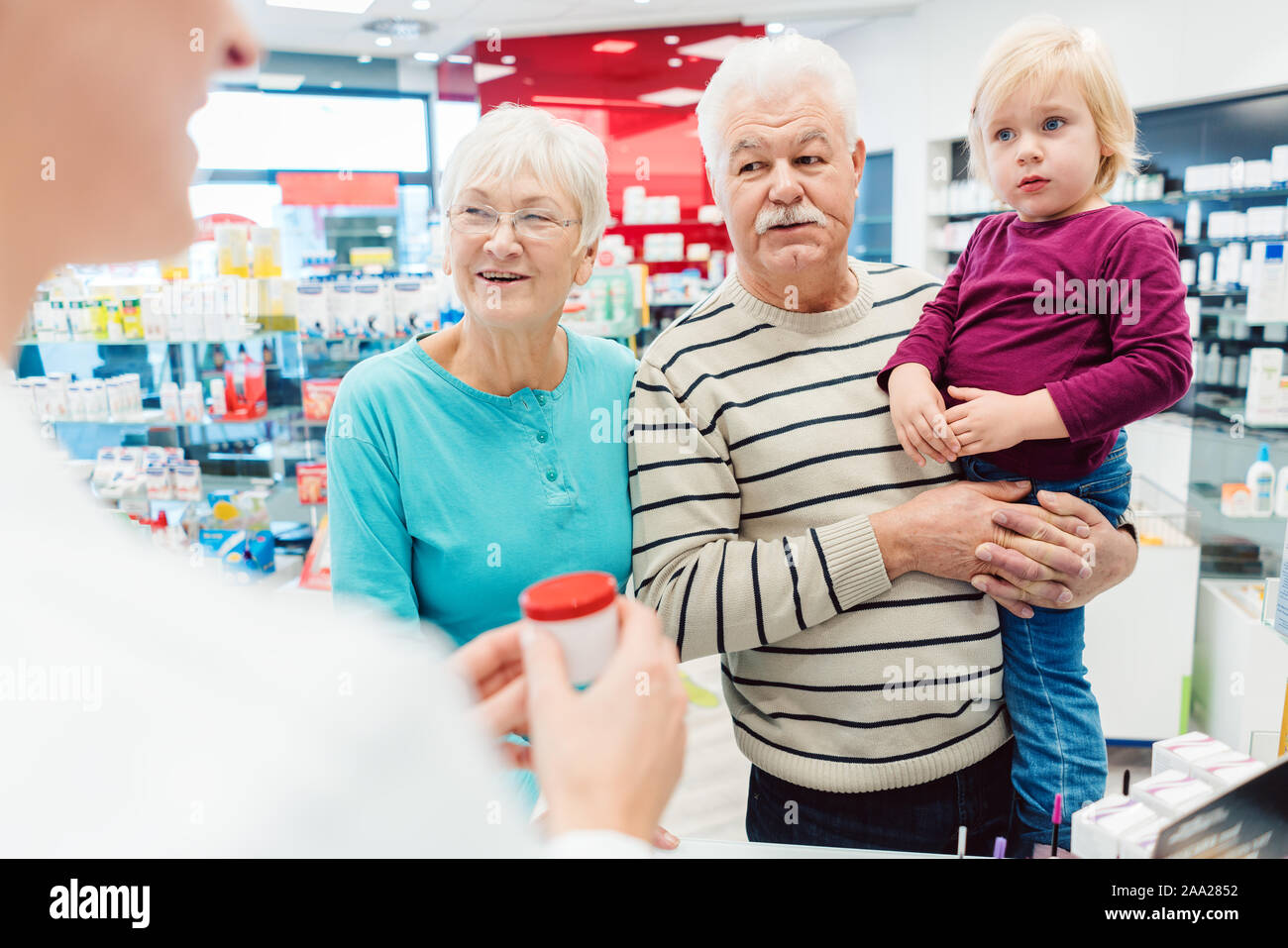 Großeltern in der Apotheke kaufen verschreibungspflichtige Medikamente für Enkel Stockfoto