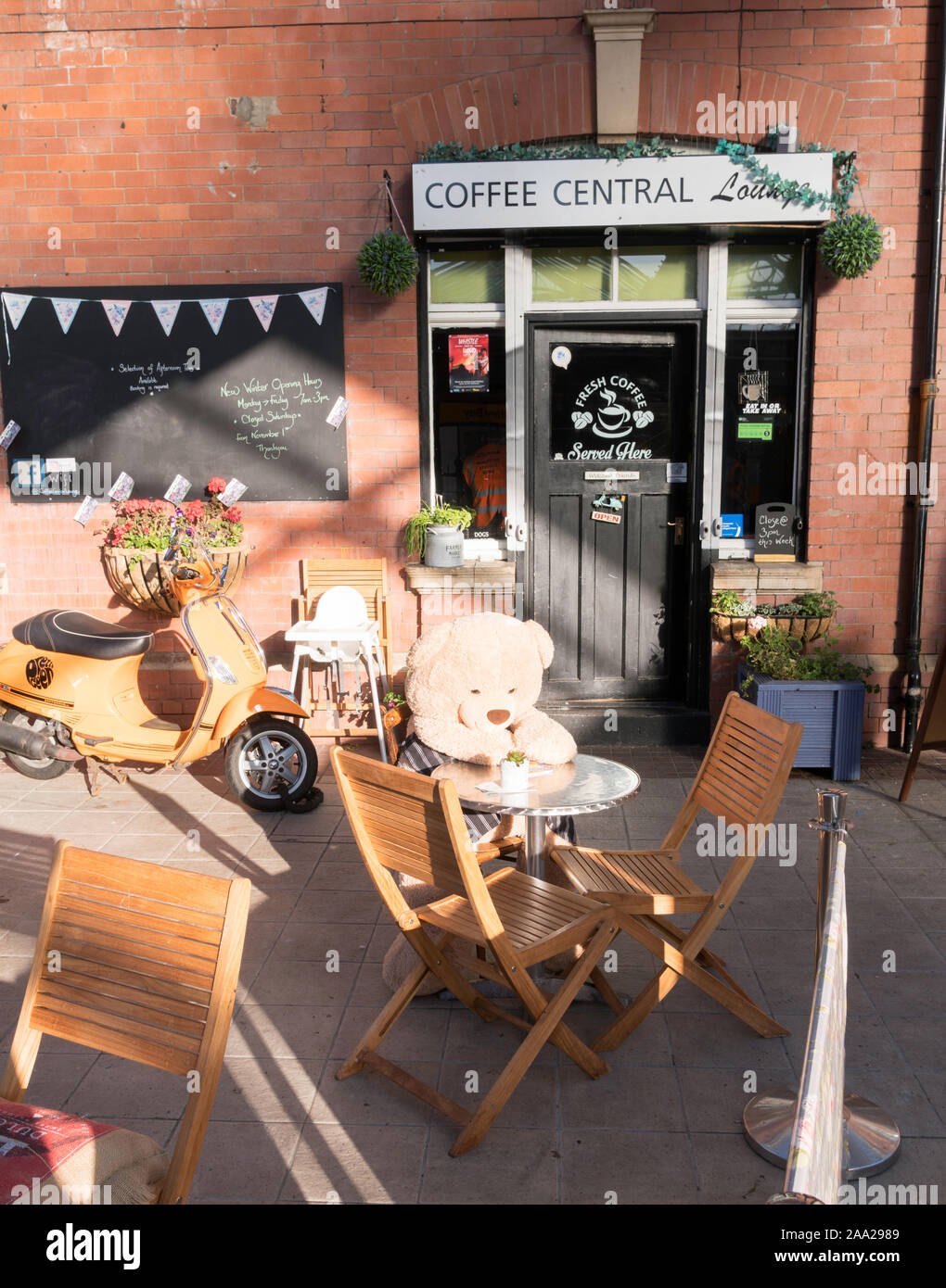 Ein Teddybär sitzt außerhalb der Kaffee Zentrale cafe in Whitley Bay U-Bahnstation, North East, England, Großbritannien Stockfoto