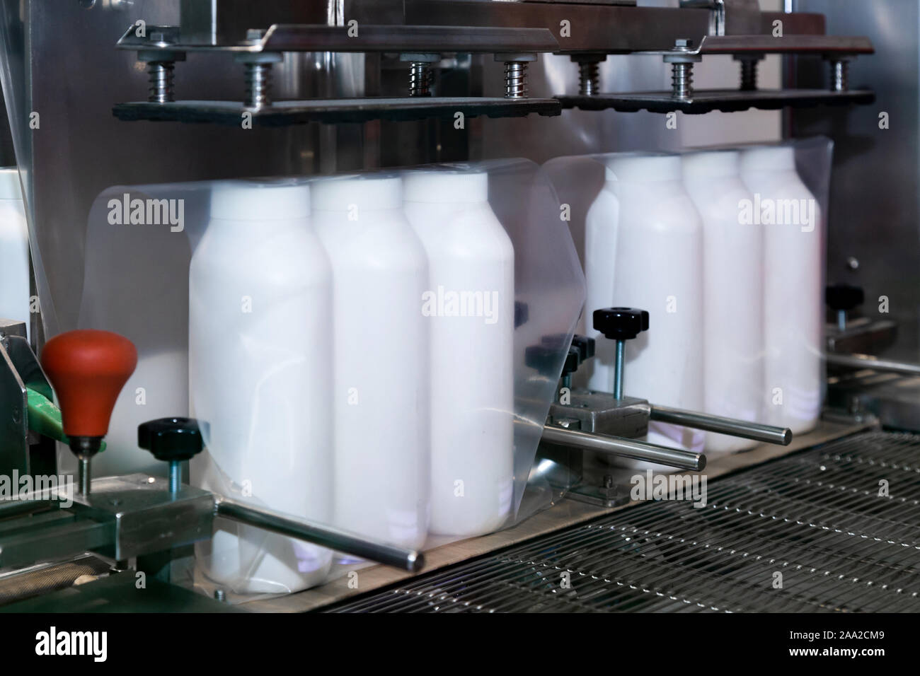 Weißer Kunststoff Flasche Baby Powder Produkte sind Umhüllung in transparente Folie auf der Verpackung der Maschine in der kosmetischen Fabrik. Stockfoto