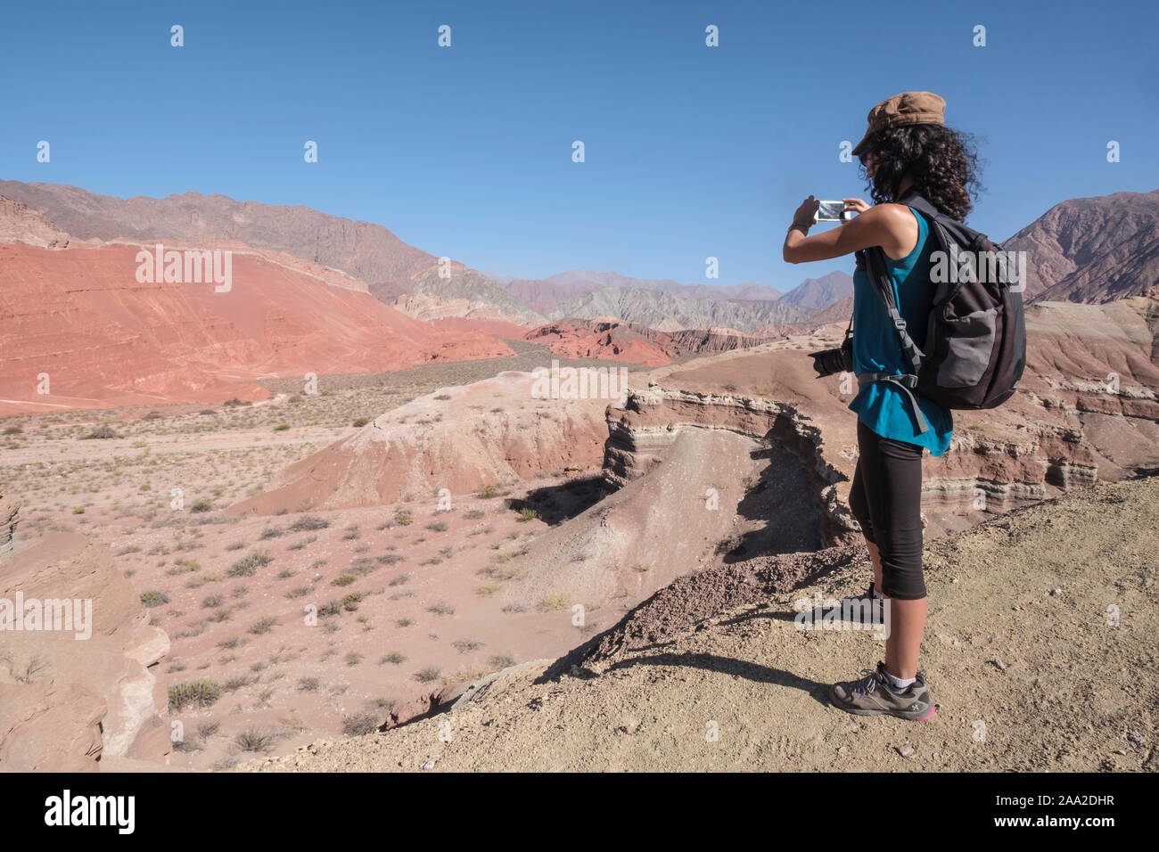 Weibliche Touristen fotografieren einen Panoramablick auf die bunten geologische Landschaft von La Yesera in der Quebrada de las Conchas, Cafayate, Argentinien Stockfoto