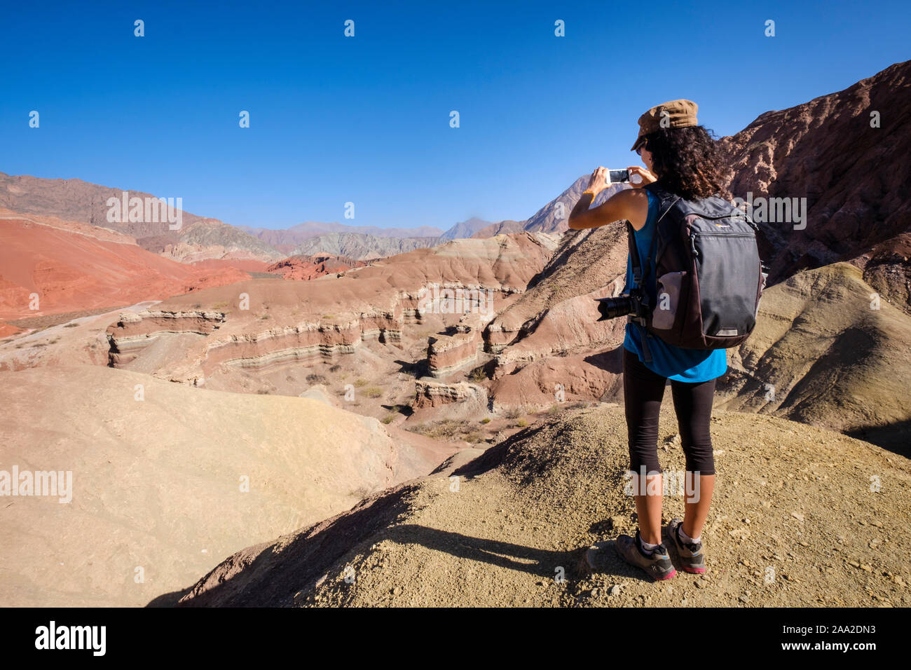 Weibliche Touristen fotografieren einen Panoramablick auf die bunten geologische Landschaft von La Yesera in der Quebrada de las Conchas, Cafayate, Argentinien Stockfoto