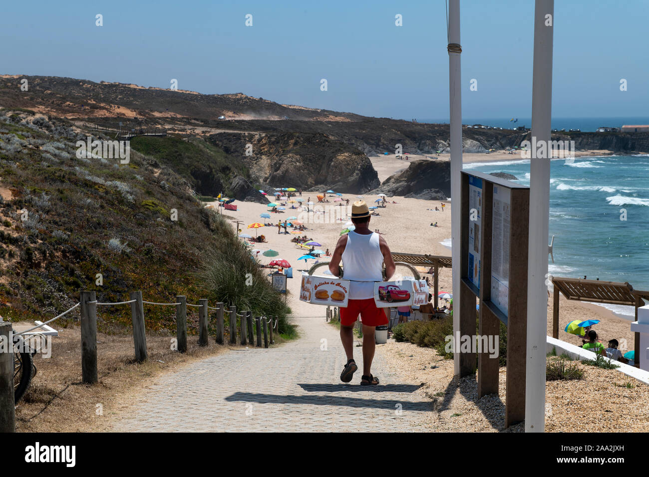 Almograve, Portugal - Juli 19, 2019: ein Mann, der Verkauf von Donuts (Bolas de Berlim) am Strand Almograve (Praia do Almograve), im Alentejo, Portugal. Stockfoto