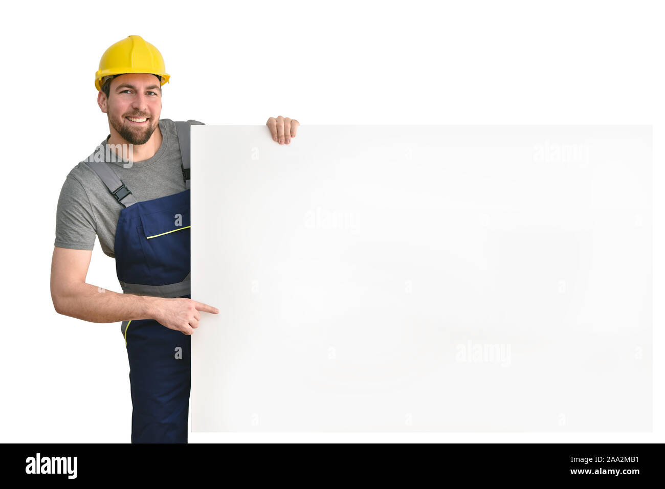 Freundliche Handwerker Punkte zu einem freien Billboard-isolierte Arbeiter mit Arbeitskleidung Stockfoto