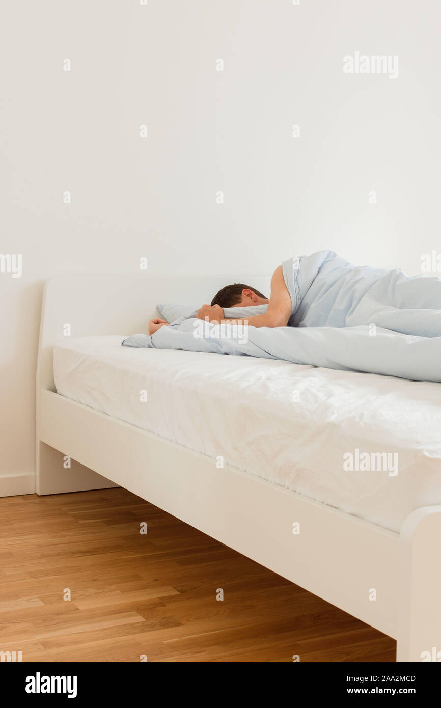 Teil der Home oder hotel Interieur, Menschen schlafen auf einem weißen Bett mit blauen Handtücher am Morgen Stockfoto