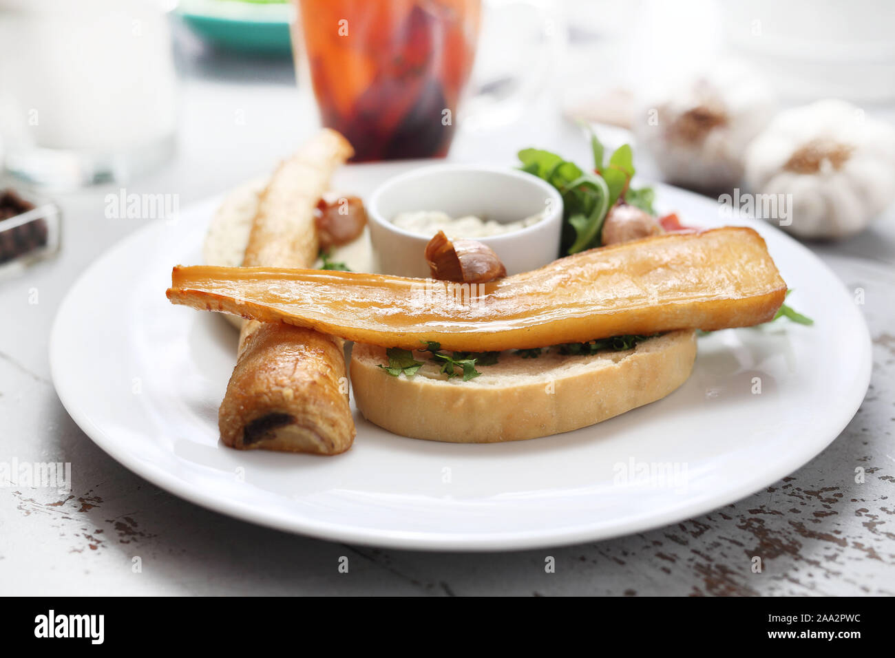 Petersilienwurzel gebacken in Honig Soße auf Toast. Rucola und Tomaten Salat, Knoblauch Sauce. Stockfoto