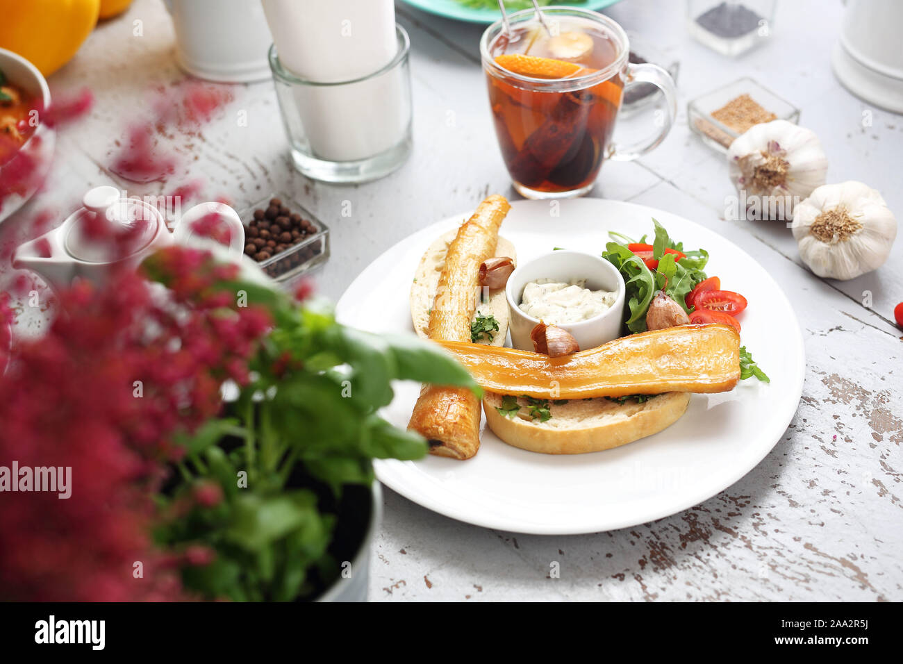 Petersilienwurzel gebacken in Honig Soße auf Toast. Rucola und Tomaten Salat, Knoblauch Sauce. Stockfoto