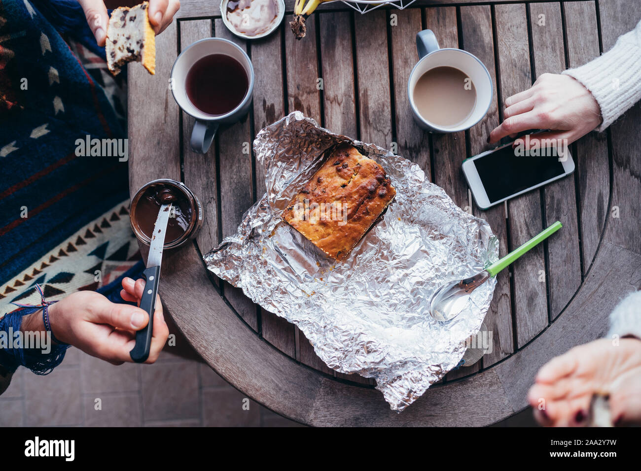 Ansicht von oben Frühstückstisch mit Smartphone und Hände von Paar in Essen - gesunde Ernährung, Technik, Qualität Konzept Stockfoto