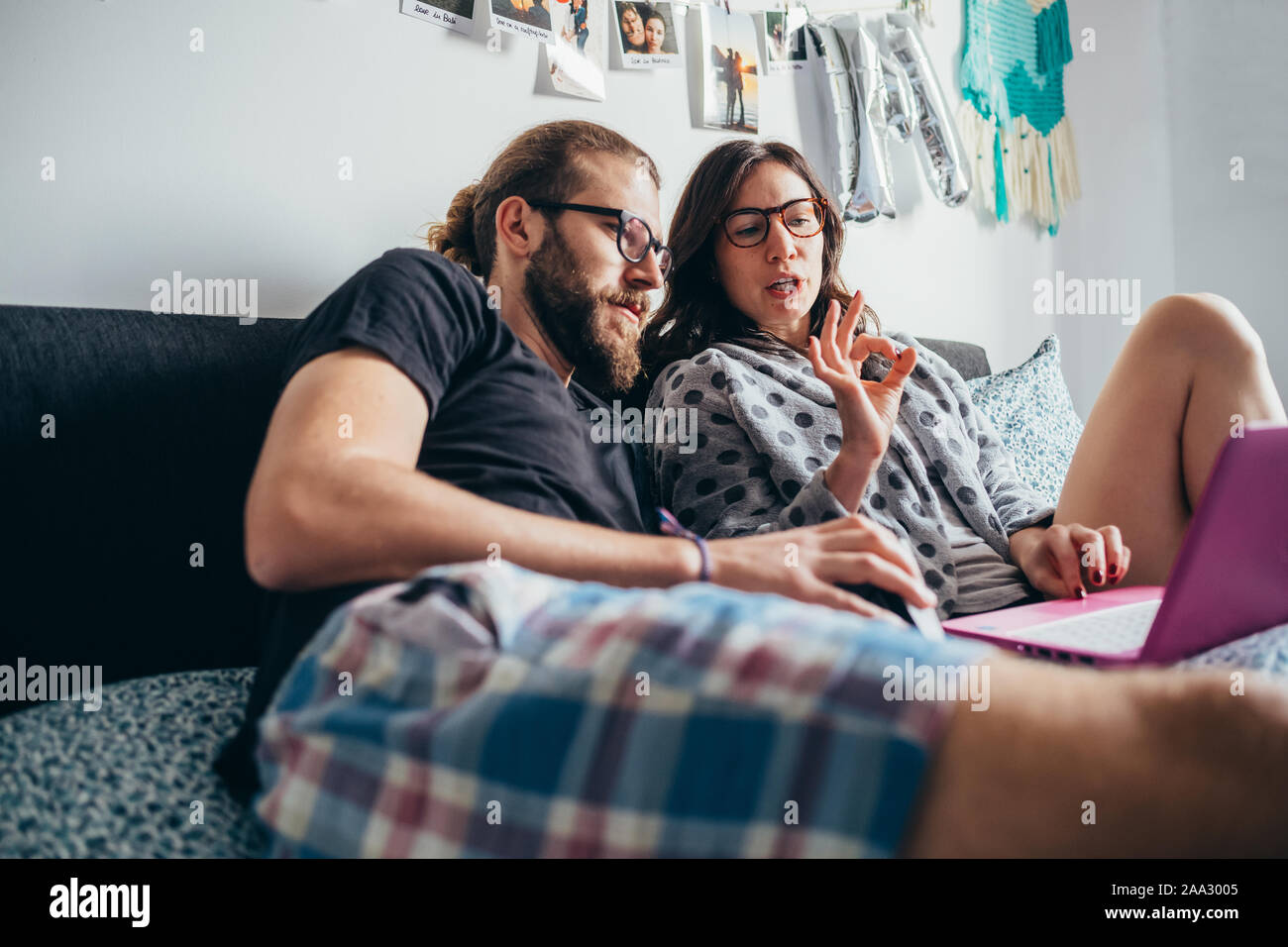 Glückliches Paar im Bett liegend Indoor auf computer-Streaming Video, buchen Reisen, Unterhaltung Konzept Stockfoto