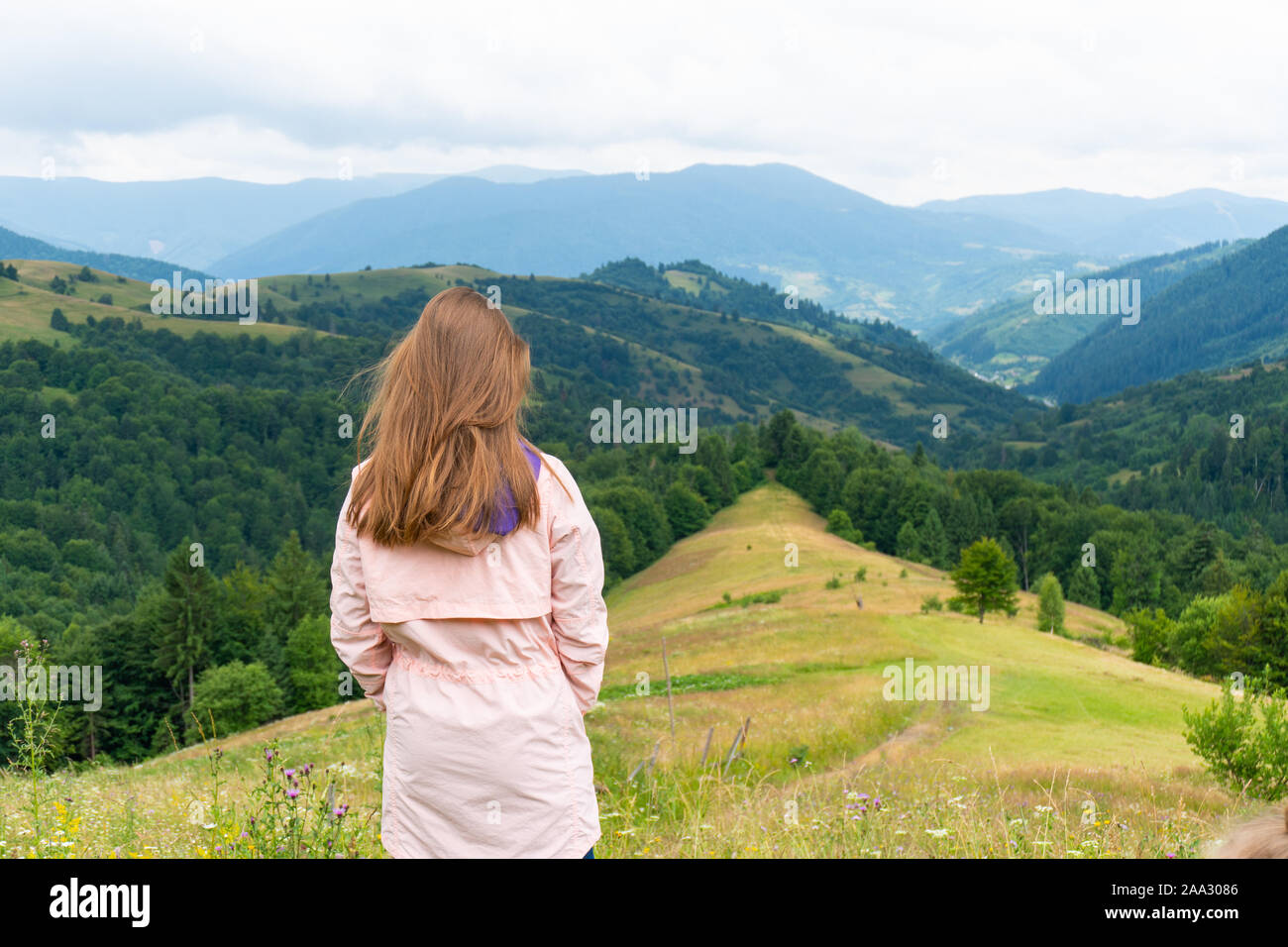 Frau, die auf einem Hügel und Berge mit Wäldern Stockfoto Frau, die auf einem Hügel und Berge mit Wäldern Stockfoto