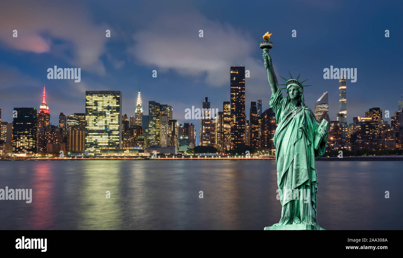Freiheitsstatue vor der Skyline von Manhattan, in der Nacht, während der blauen Stunde Stockfoto