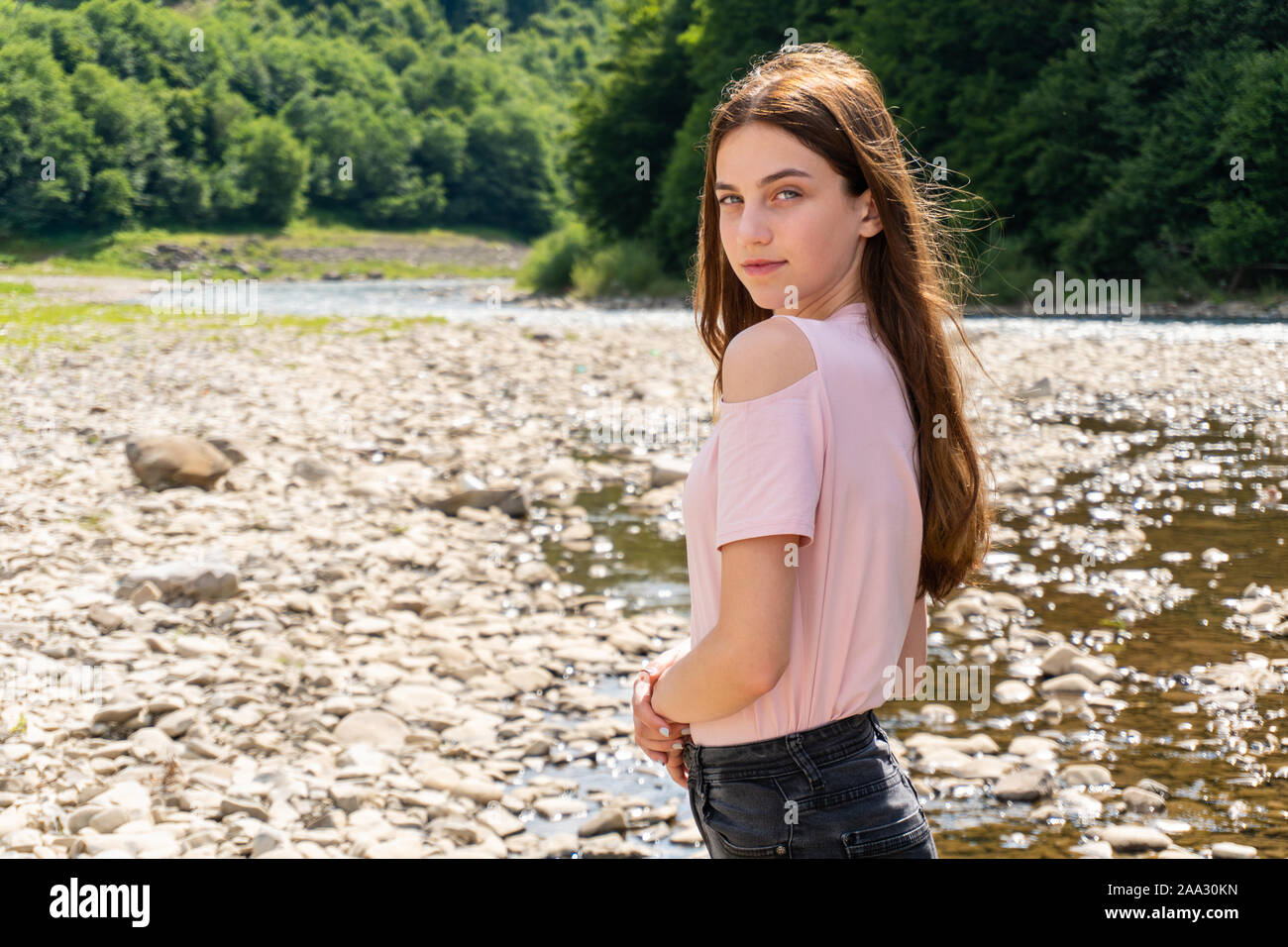 Teenager Frau Mädchen schauen in die Kamera in der Nähe von Mountain River Stockfoto