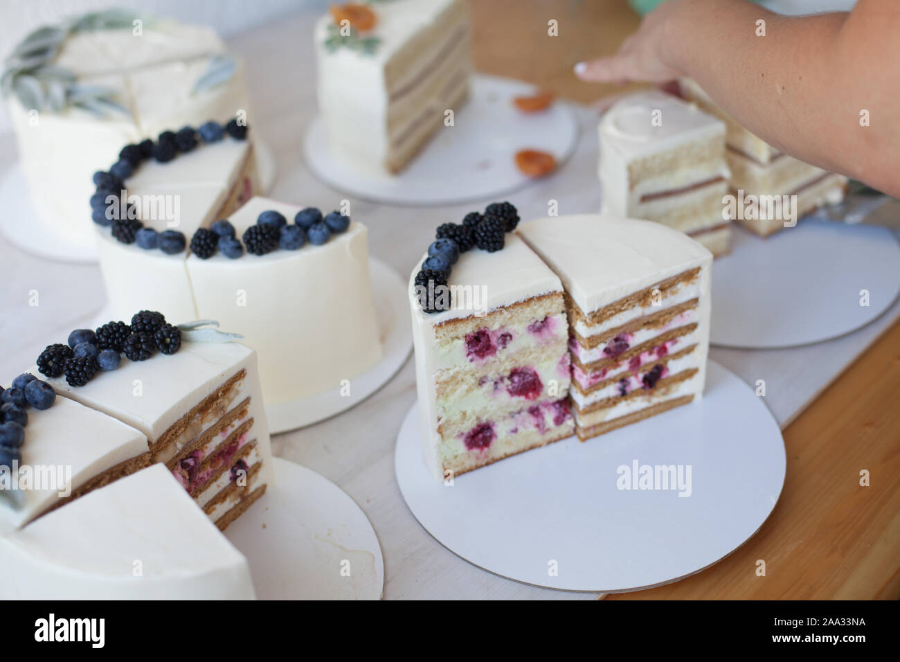 Woman's Hand griff nach einem Stück Kuchen Stockfoto