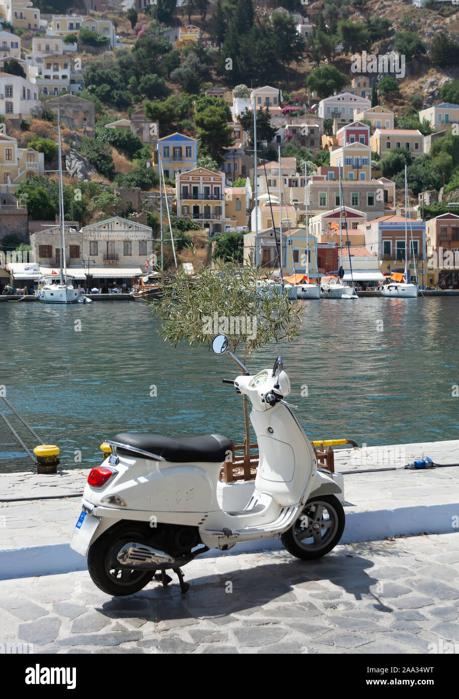 Roller auf Wasser. Bucht und alte Gebäude im Hintergrund. Wunderschöne griechische Insel Symi. Dodekanes Griechenland Stockfoto