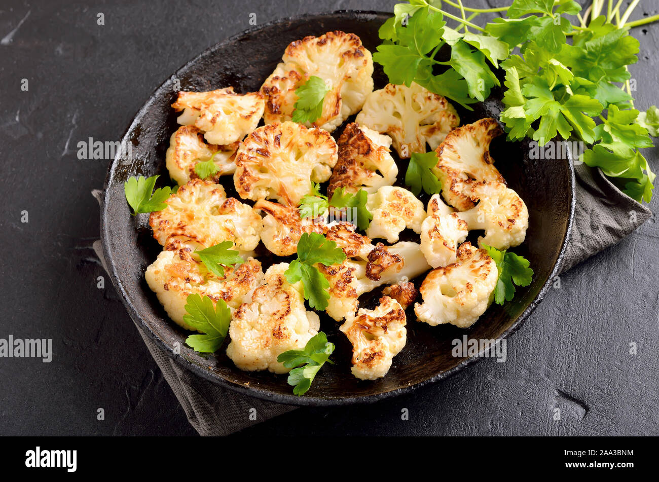 Gebratener Blumenkohl mit Kräutern und Gewürzen auf Platte, Ansicht schließen Stockfoto