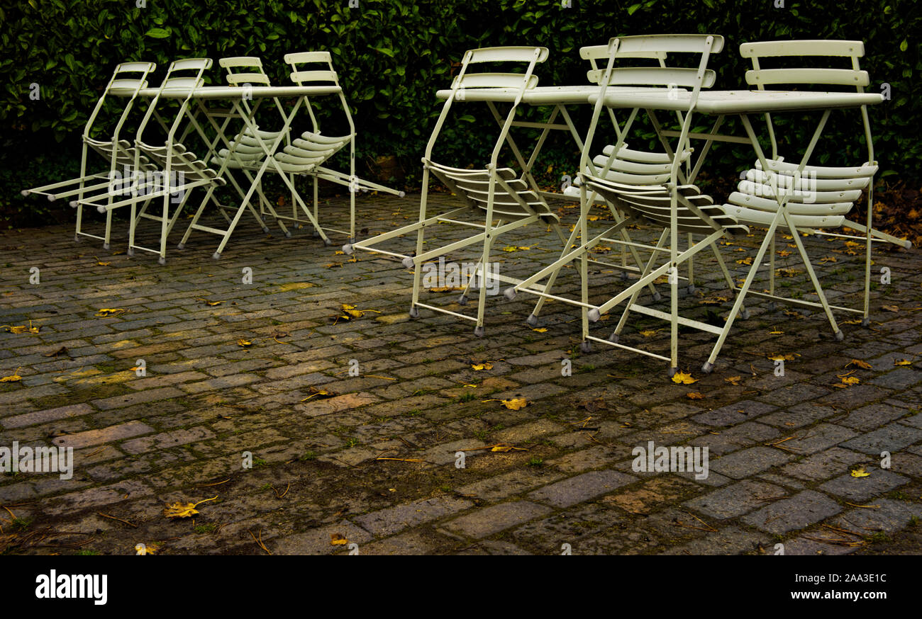 Stühle und Tische von einem Café im Freien am Ende der Saison Stockfoto