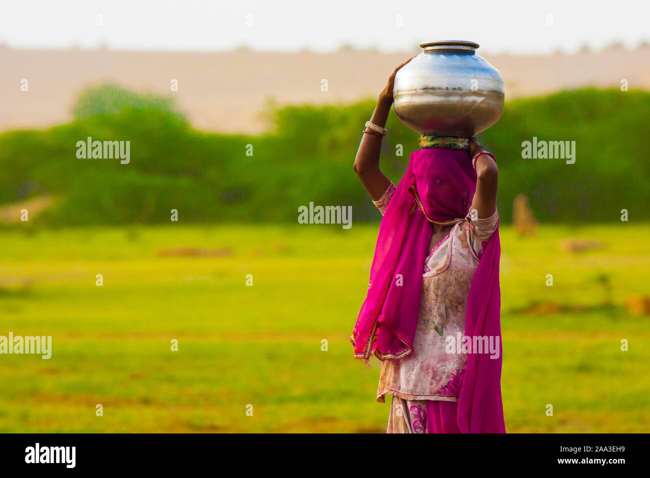 Frau carryng Wasser Stockfoto
