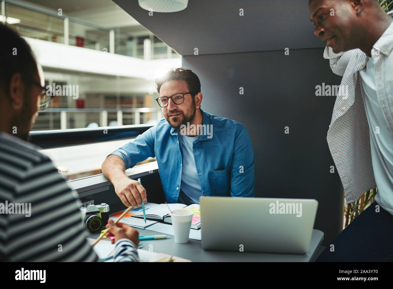 Team von kreativen Arbeiten an einem Projekt zusammen während der Sitzung in einer Sitzung pod in der Lobby eines modernen Büro Stockfoto