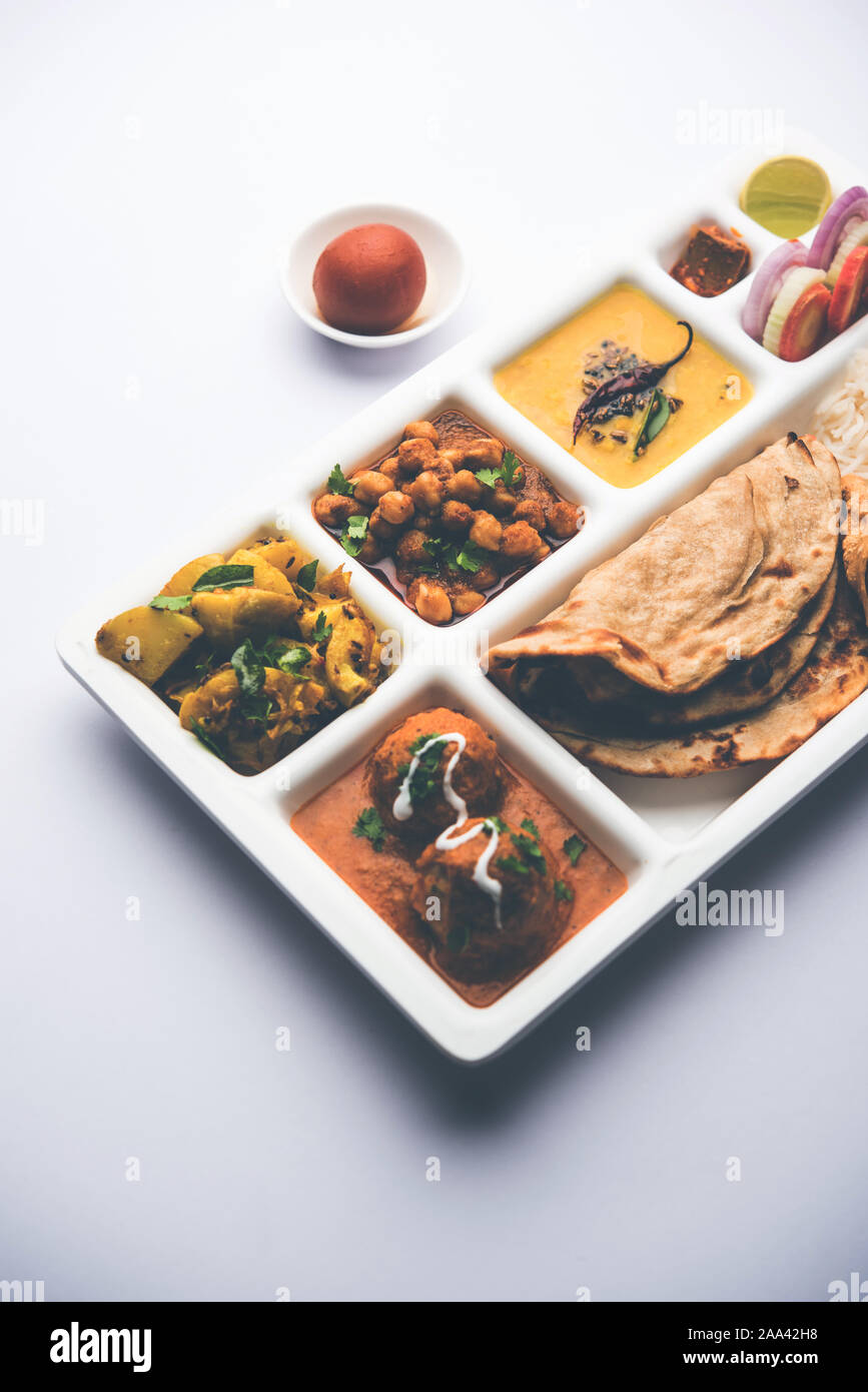 Indische vegetarische Nahrung Thali oder Paket essen - Fach mit Fächern, in denen Malai Kofta, chole, Dal Tarka, chemische aloo Sabji, chapati und Reis mit süßer Stockfoto