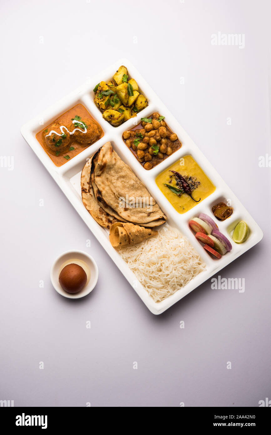 Indische vegetarische Nahrung Thali oder Paket essen - Fach mit Fächern, in denen Malai Kofta, chole, Dal Tarka, chemische aloo Sabji, chapati und Reis mit süßer Stockfoto