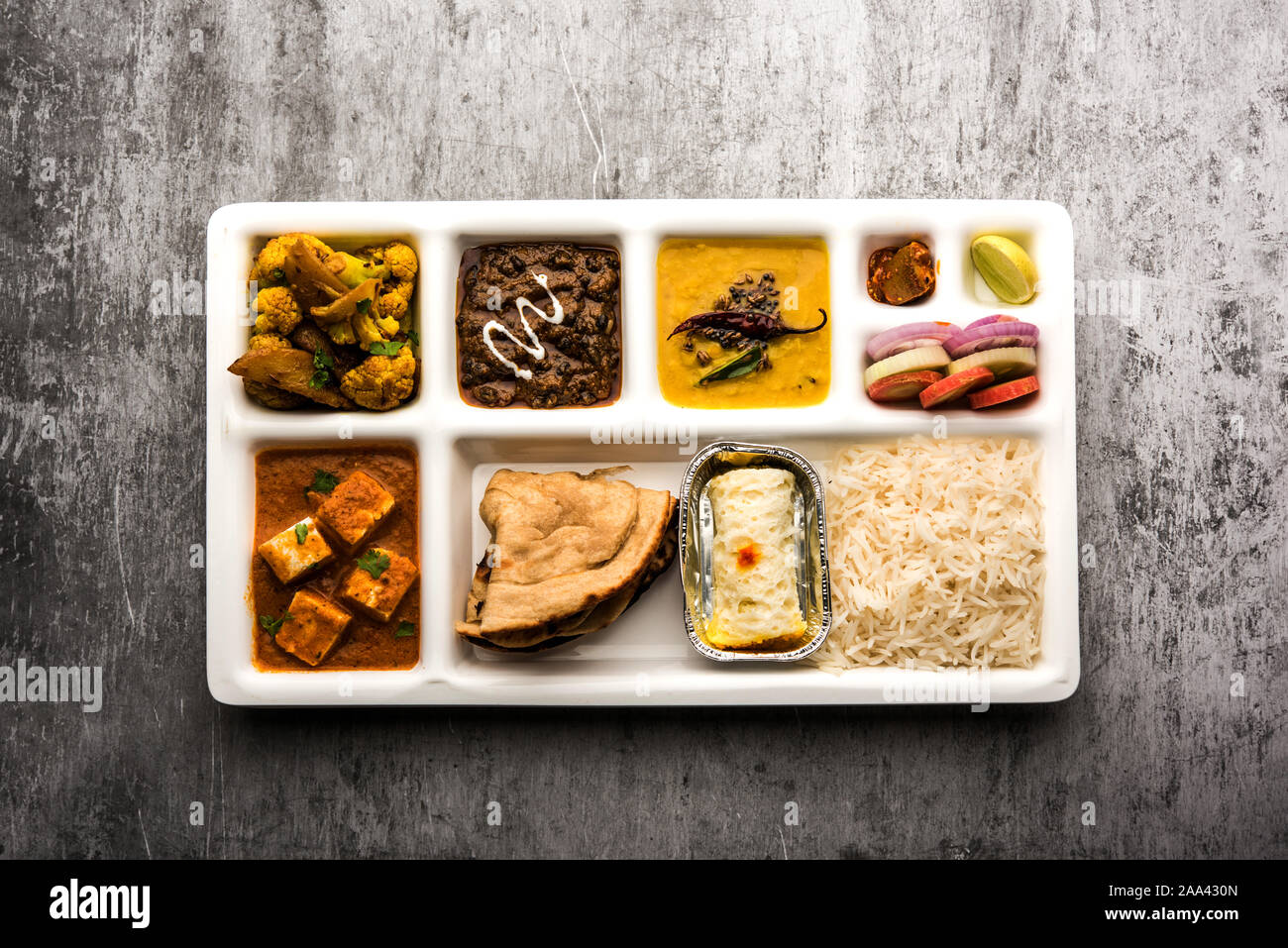 Indische vegaterian Essen Thali oder Paket essen - Fach mit Fächern, in denen Paneer, dal makhani/Parka, Aloo Gobi - sabji, chapati und Reis mit Bengal Stockfoto