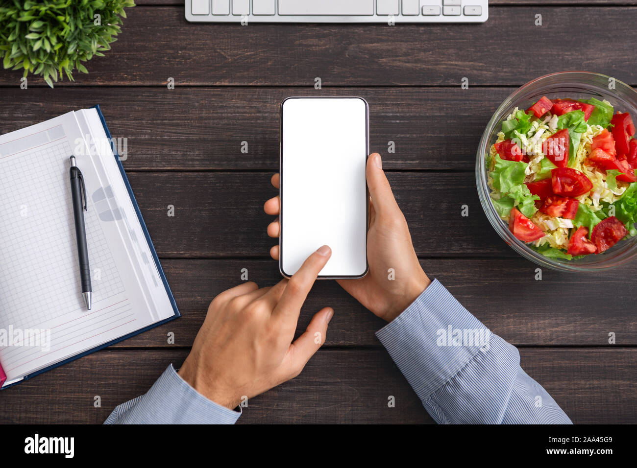 Mann mit Smartphone mit leerer Bildschirm und Essen Salat Stockfoto
