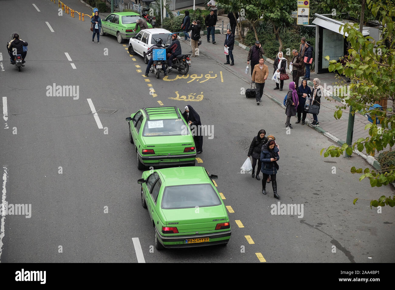 Teheran, Iran. Nov, 2019 19. Die Menschen warten an einer Bushaltestelle in der Innenstadt von Teheran. Iran hat die Zugeschlagen ein US für die "Randalierer", nach heftigen Protesten durch eine Entscheidung benzin Preiserhöhungen zu verhängen gefunkt und Rationierung in der Sanktionen - hit Land. Die Situation auf den Straßen wurde am Montag morgen unklar, vor allem wegen der Internet-ausfall, der den Fluss von Videos auf Social Media von Protest oder damit verbundenen Gewalttaten shared eingedämmt hat. Ein Artikel veröffentlicht am Dienstag in Keyhan, eine harte Linie Zeitung im Iran vorgeschlagen, dass die geführten heftigen Protesten wird durch hängen als die ausgeführt werden. Stockfoto