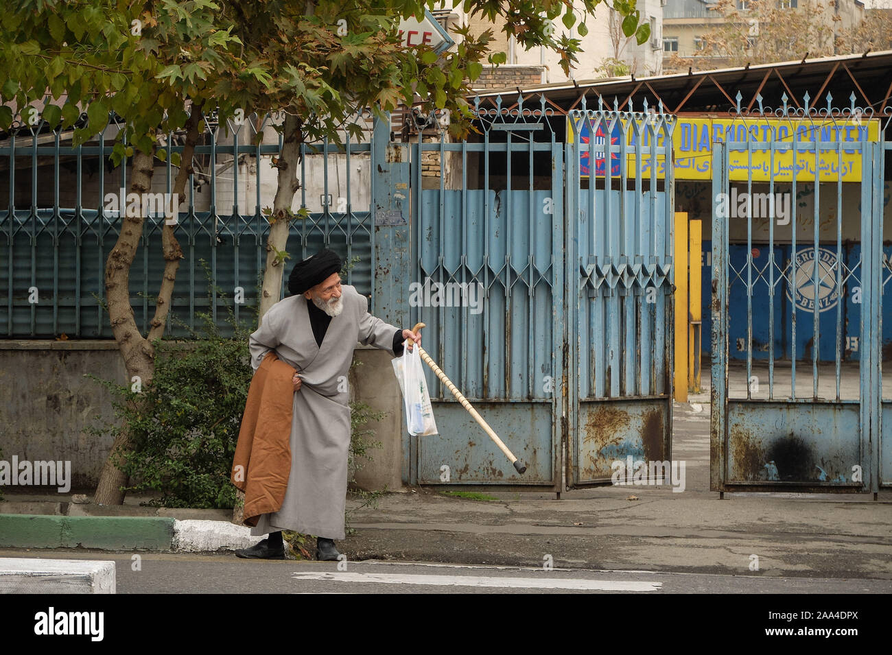 Teheran, Iran. Nov, 2019 19. Ein geistlicher Mensch kreuzt eine Straße in der Innenstadt von Teheran. Iran hat die Zugeschlagen ein US für die "Randalierer", nach heftigen Protesten durch eine Entscheidung benzin Preiserhöhungen zu verhängen gefunkt und Rationierung in der Sanktionen - hit Land. Die Situation auf den Straßen wurde am Montag morgen unklar, vor allem wegen der Internet-ausfall, der den Fluss von Videos auf Social Media von Protest oder damit verbundenen Gewalttaten shared eingedämmt hat. Ein Artikel veröffentlicht am Dienstag in Keyhan, eine harte Linie Zeitung im Iran vorgeschlagen, dass die geführten heftigen Protesten wird durch Hängen als ausgeführt werden Stockfoto