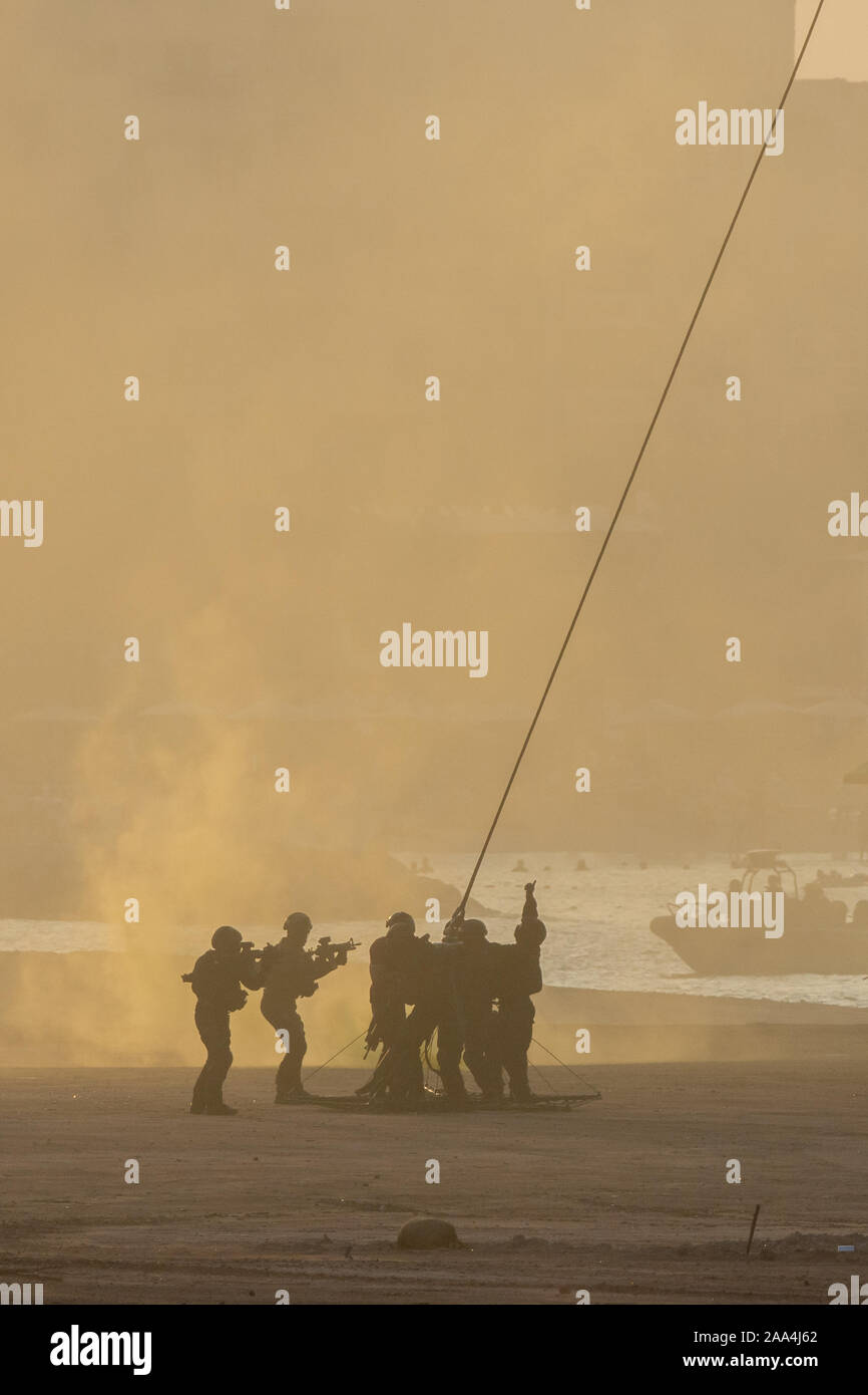 Militärische Team resucing Menschen in Konflikt mit dem Hubschrauber. Erste Schritte auf dem Seil befestigt im Rauch und Dunst in den Nahen Osten zu Chopper conflic geladen Stockfoto