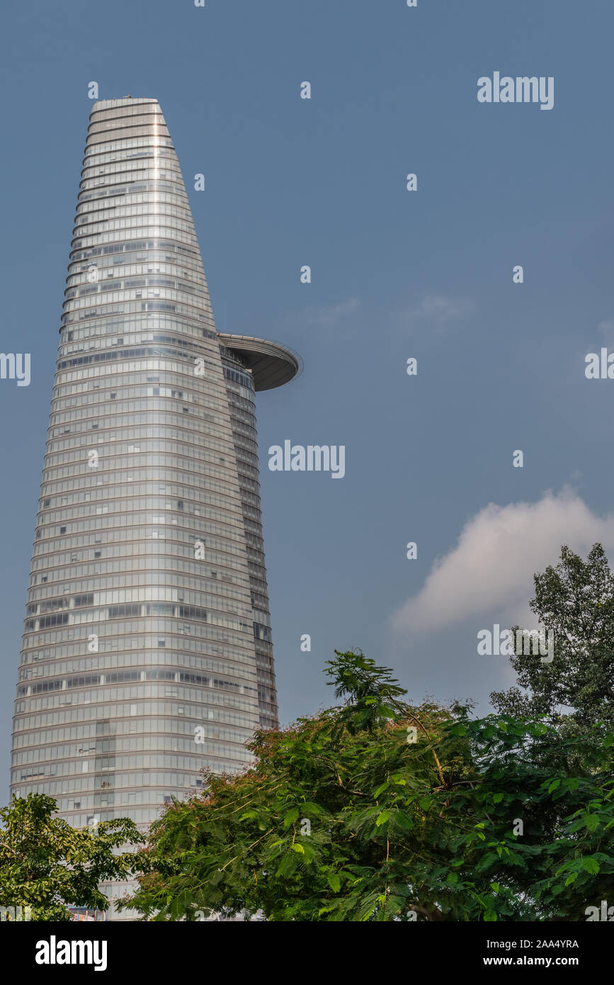 Ho Chi Minh City, Vietnam - 12. März 2019: Straße der Innenstadt Landschaft. Grau Bitexco Financial Tower gegen den blauen Himmel mit grünem Laub am Fuß. Stockfoto