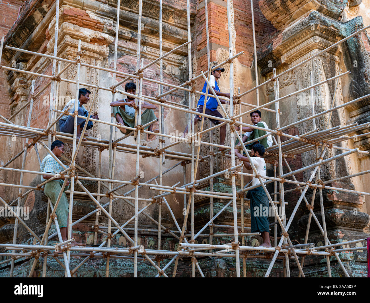 Arbeitnehmer konstruieren die Einrüstung der Fassade eines alten buddhistischen Tempel in der archäologischen Zone von Bagan, Myanmar (Birma). Stockfoto