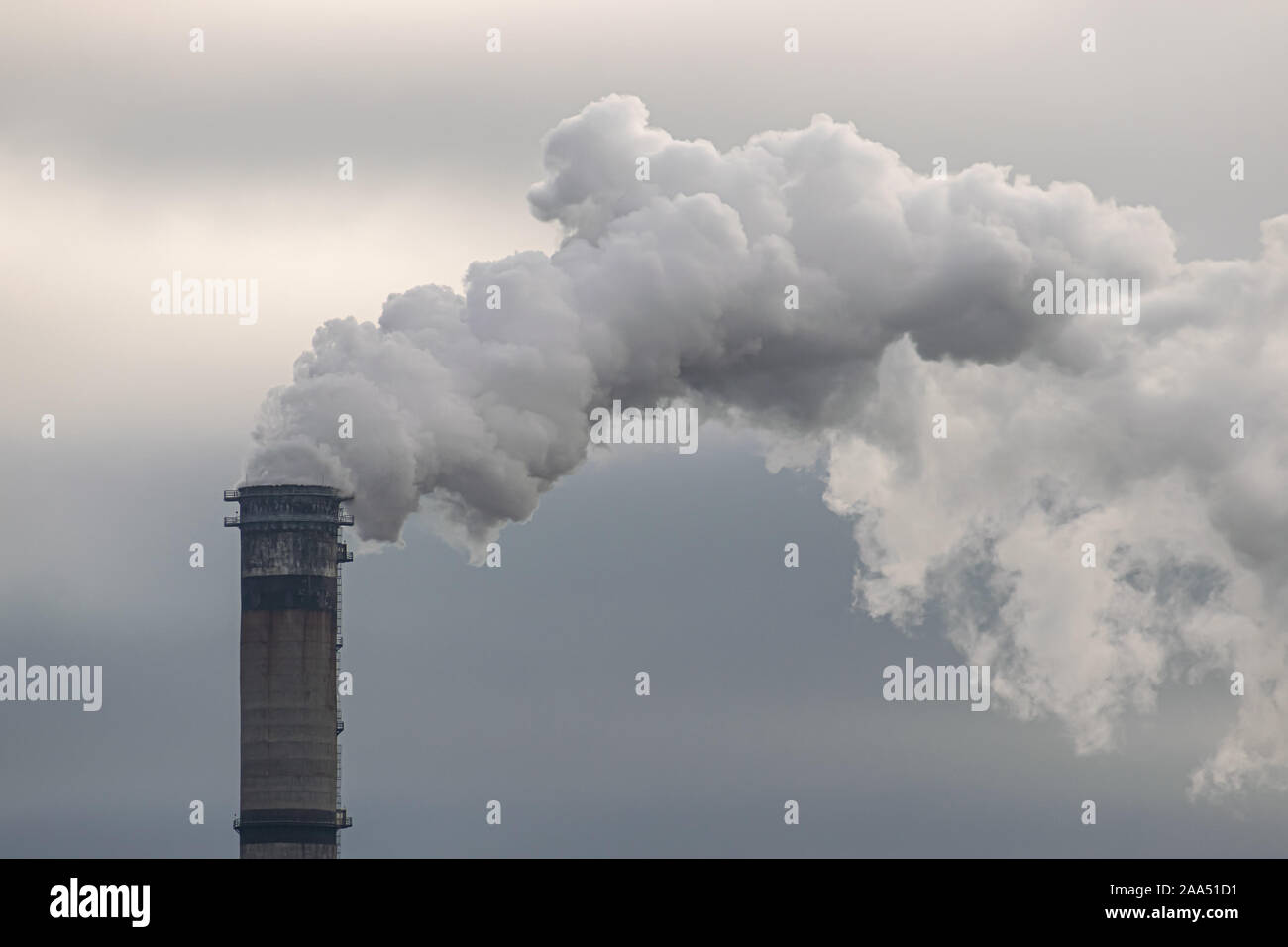 Rauch und Dampf erzeugt aus dem Schornstein gegen dunkle stürmischen Himmel Stockfoto