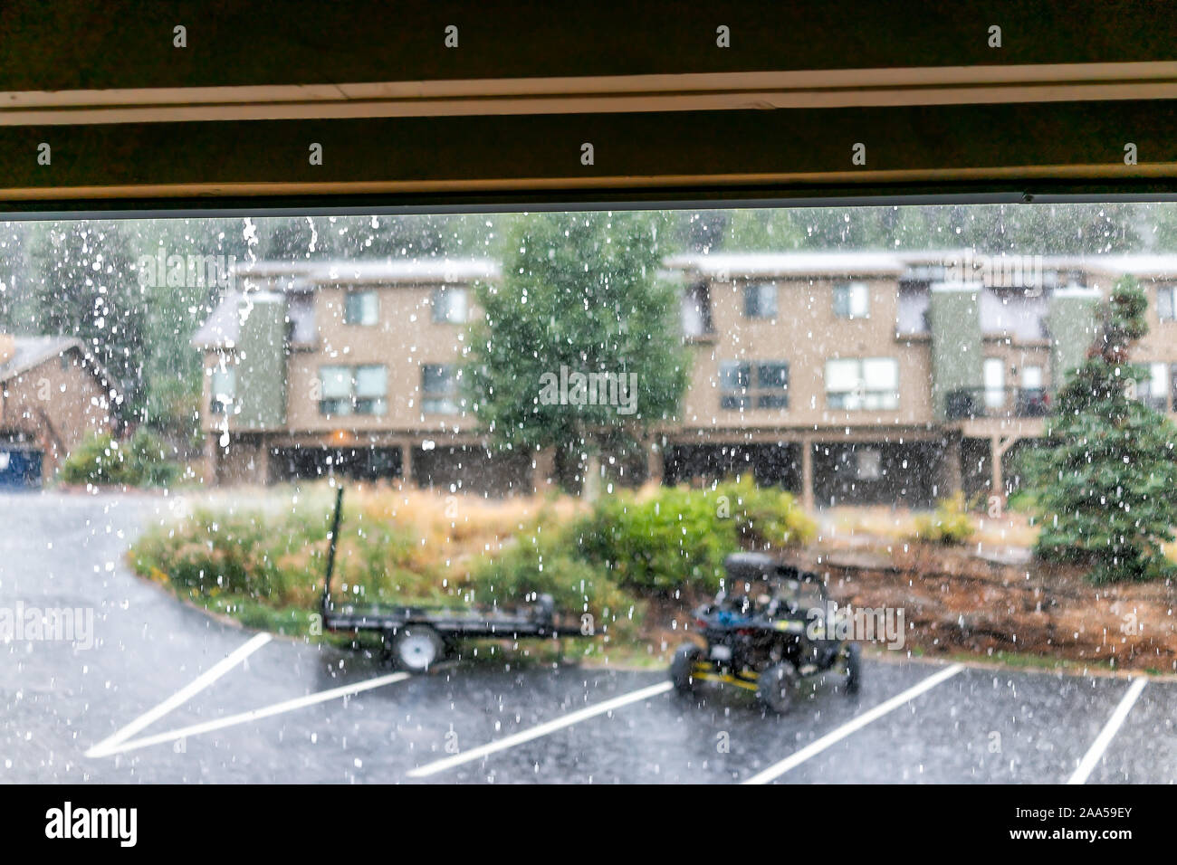 Regnerische Wetter Tag in der Wohnung Eigentumswohnung komplexe Gebäude mit Regenwasser außerhalb fallen und Vordergrund der gedeckten Dach unter Balkon Stockfoto