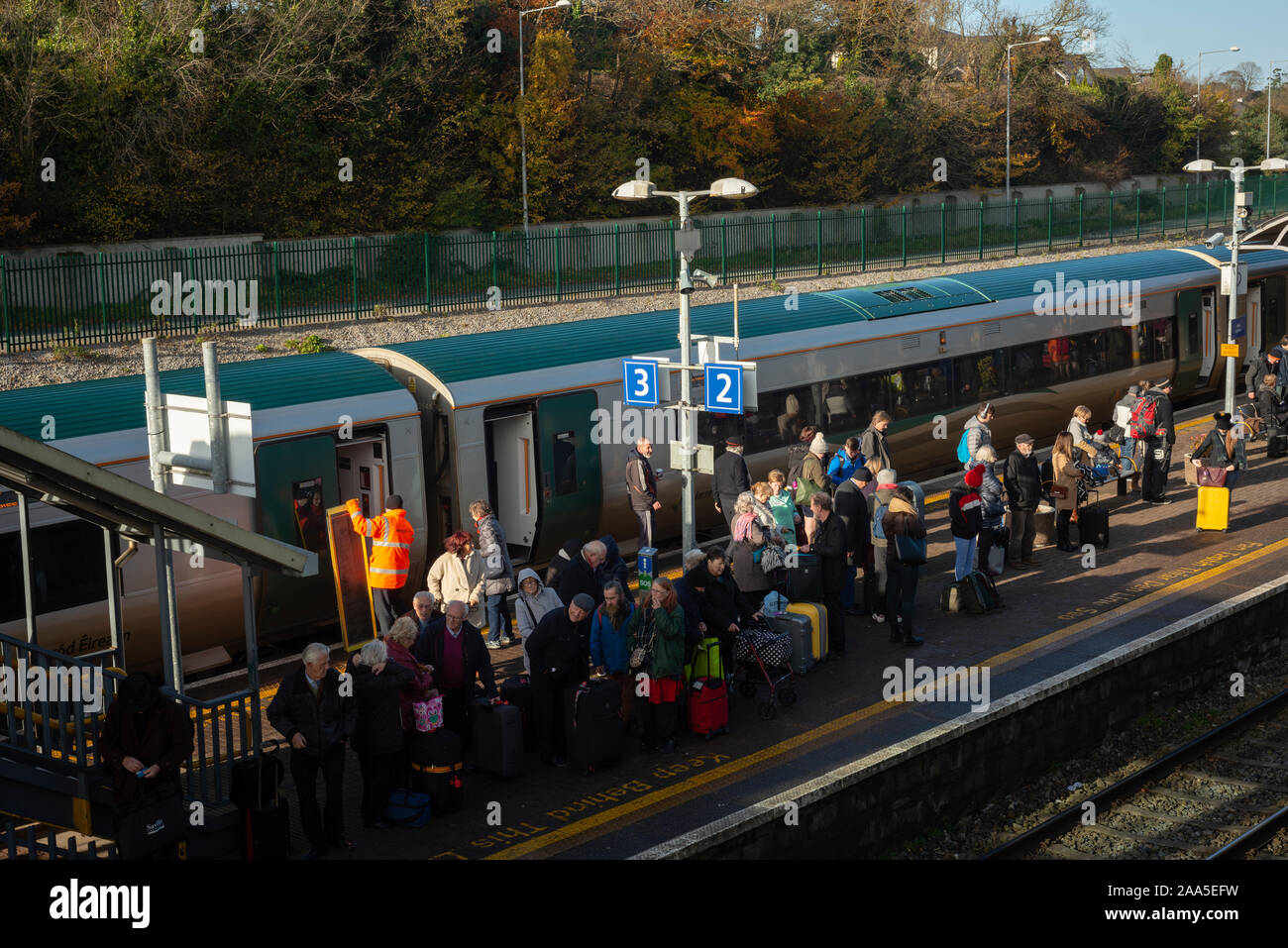 Passagiere der Irish Rail, die am Bahnsteig von Mallow auf eine Verbindung warten, da der Bahnhof ein wichtiger Verkehrsknotenpunkt in Irland ist. Stockfoto