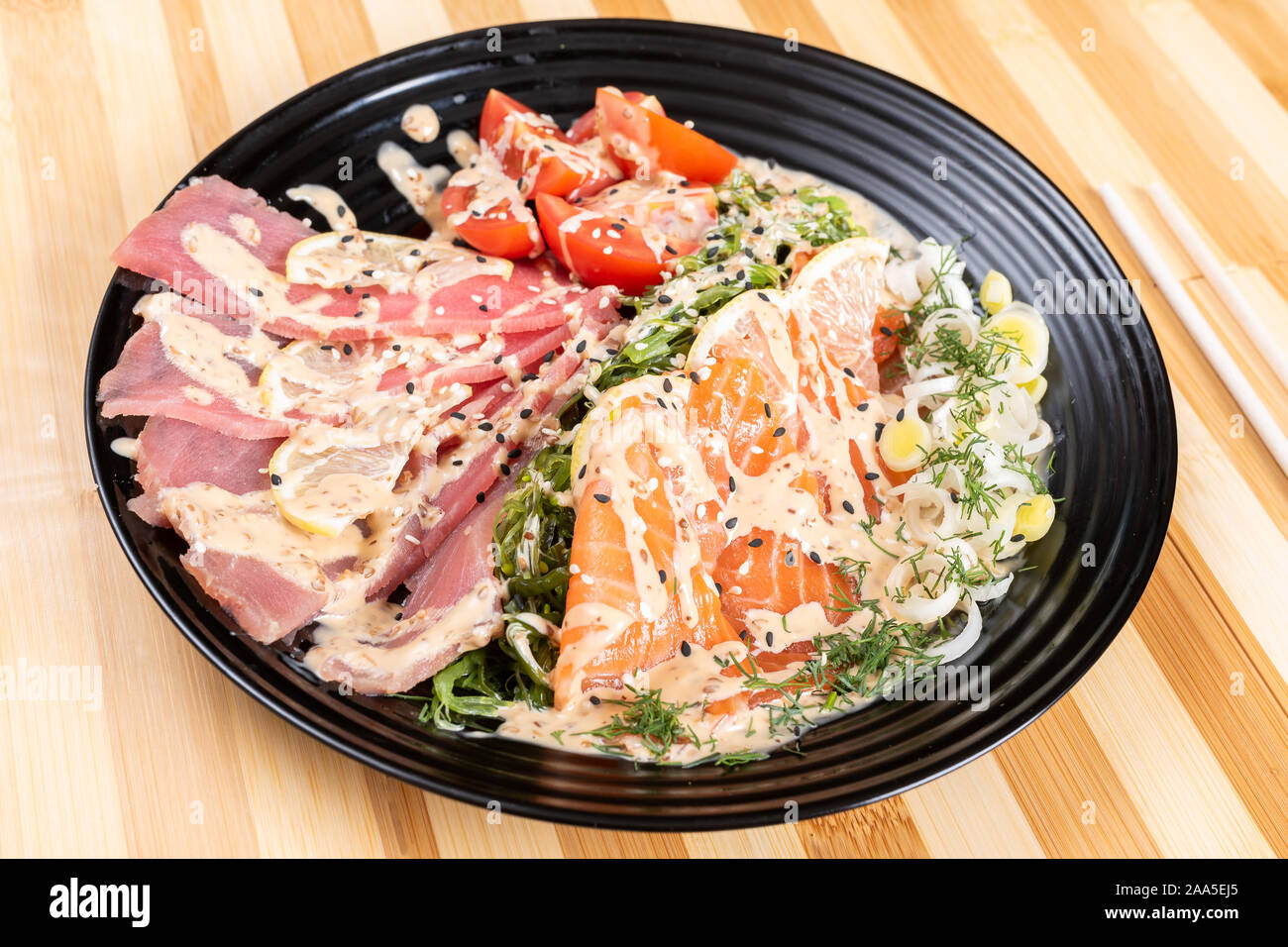 Lachs und Thunfisch Sashimi in einem Salat mit Kräutern. Stockfoto