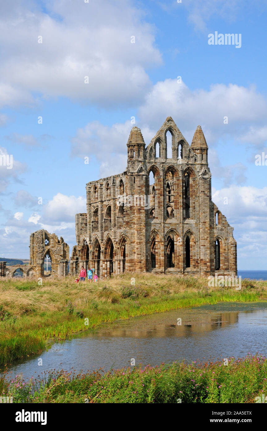 Besucher verlassen Whitby Abbey. Reflexion in den Teich. Porträt. Stockfoto