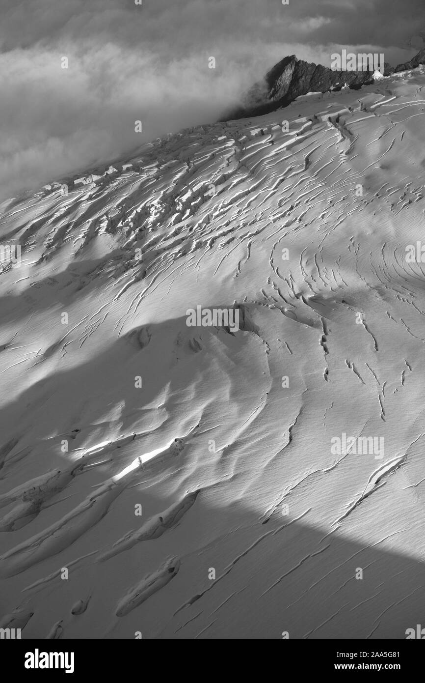 Schwarz und weiß Luftaufnahme eines Berges Seite und Gletscherspalte eingereicht glazialen Schneefeld in der Chugach Mountains, Alaska Stockfoto