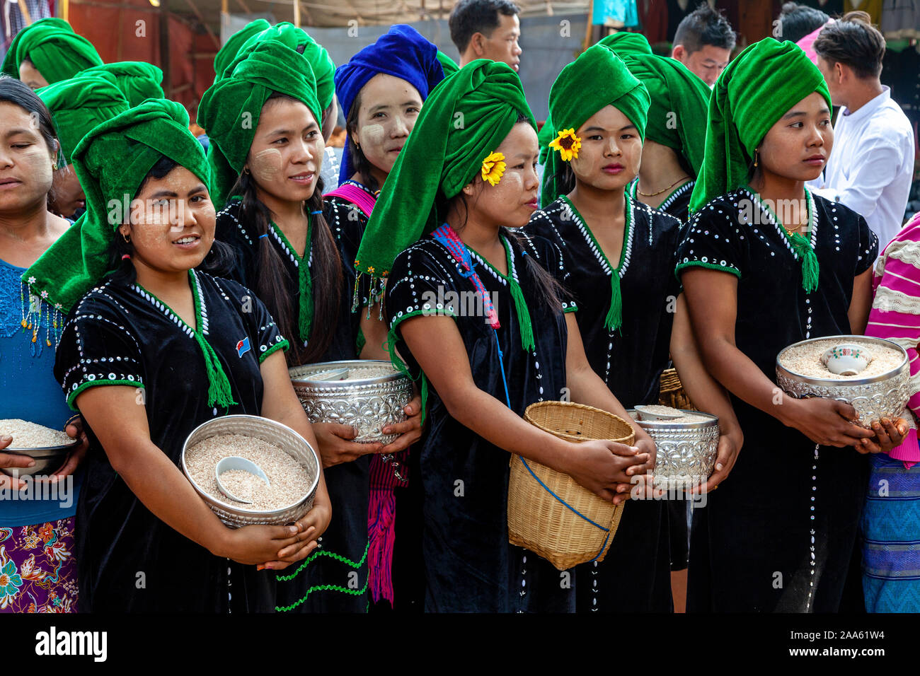 Junge Frauen, die ethnischen Minderheiten angehören, Warten, Almosen zu geben, Mönche, die Teil in einer Prozession, die Pindaya Cave Festival, Pindaya, Shan Staat, Myanmar Stockfoto