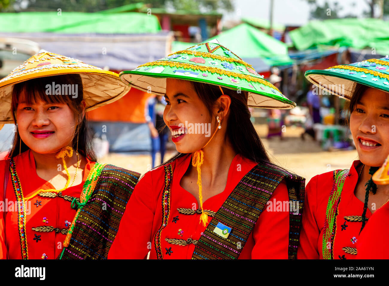Junge Frauen, die ethnischen Minderheiten angehören, Warten, Almosen zu geben, Mönche, die Teil in einer Prozession, die Pindaya Cave Festival, Pindaya, Shan Staat, Myanmar Stockfoto