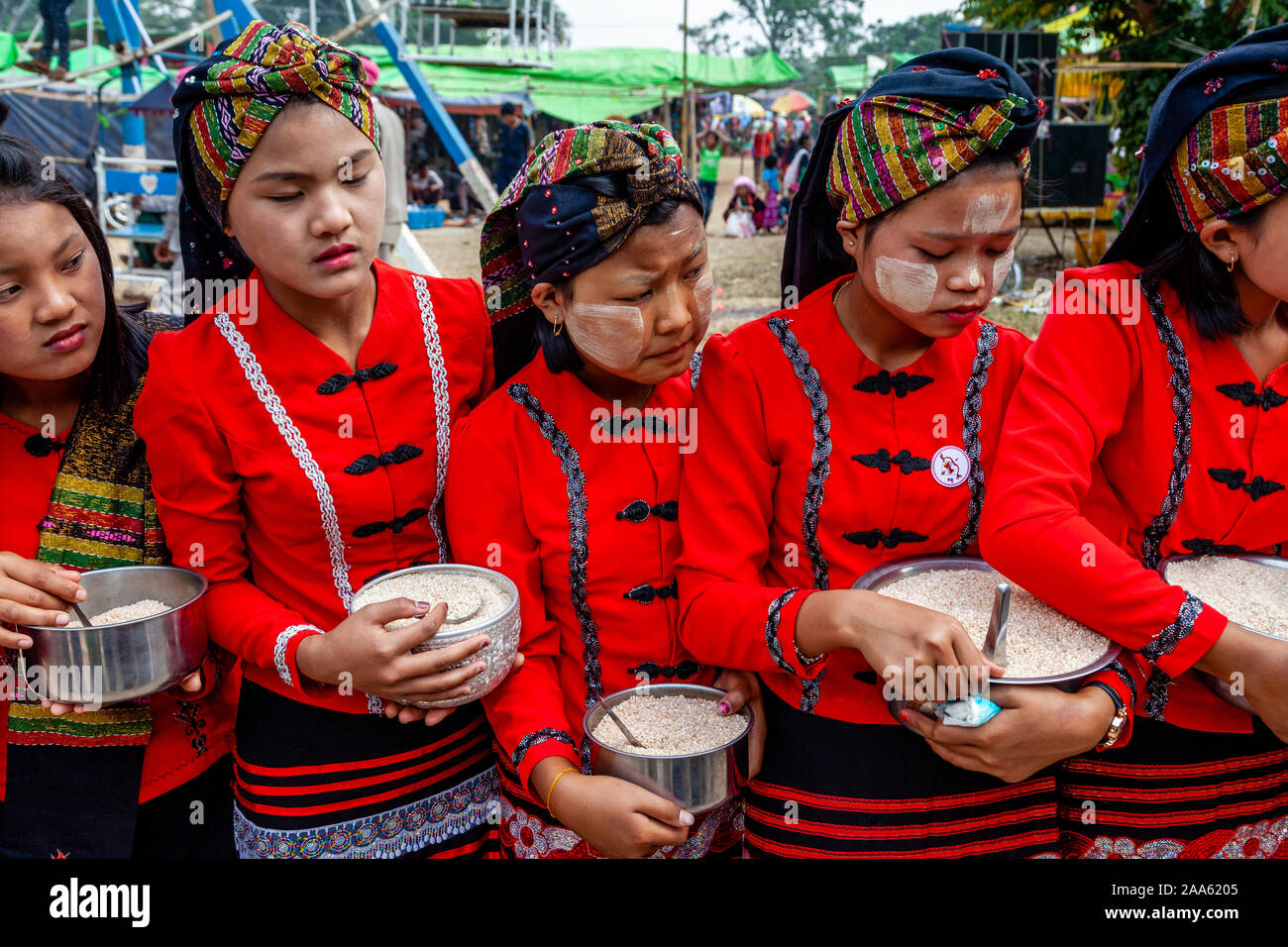 Junge Frauen, die ethnischen Minderheiten angehören, Warten, Almosen zu geben, Mönche, die sich an der traditionellen Prozession, Pindaya, Shan Staat, Myanmar zu nehmen Stockfoto