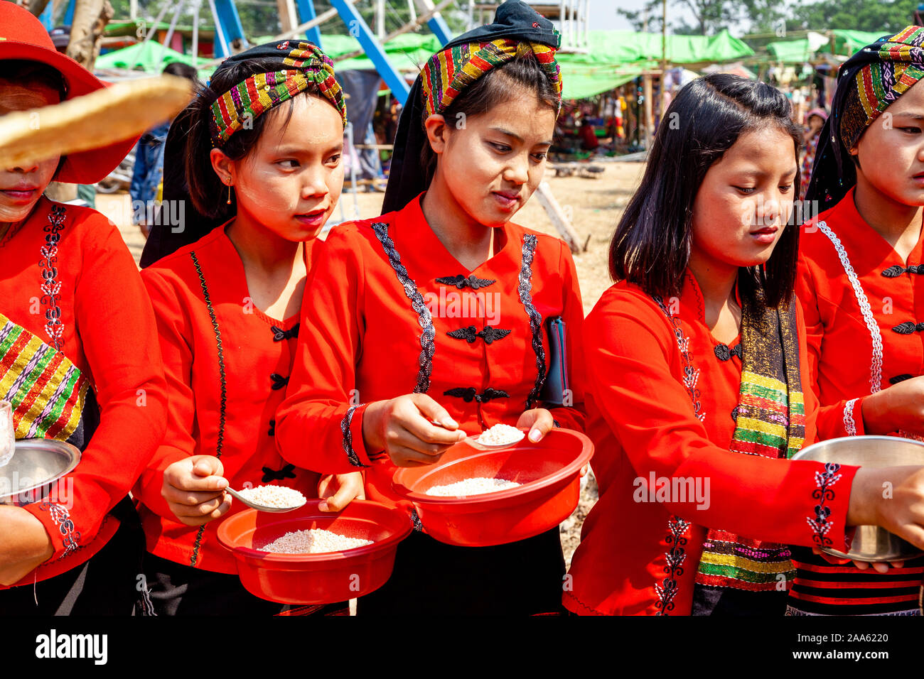 Junge Frauen, die ethnischen Minderheiten angehören, Almosen/Essen den Mönchen, die Teil in einer Prozession, die Pindaya Cave Festival, Pindaya, Shan Staat, Myanmar Stockfoto