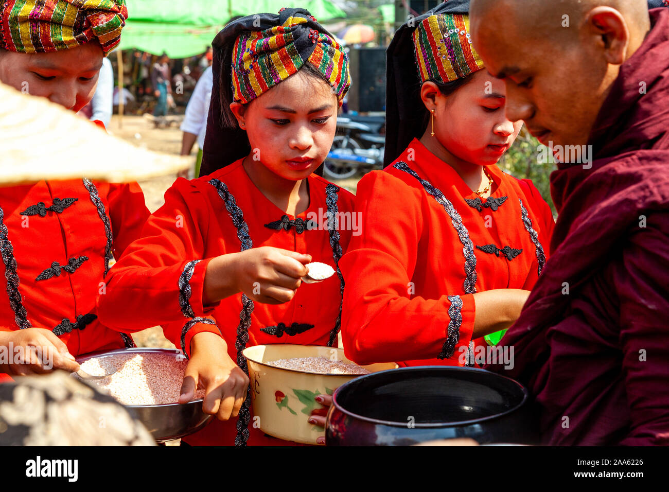 Junge Frauen, die ethnischen Minderheiten angehören, Almosen/Essen den Mönchen, die Teil in einer Prozession, die Pindaya Cave Festival, Pindaya, Shan Staat, Myanmar Stockfoto