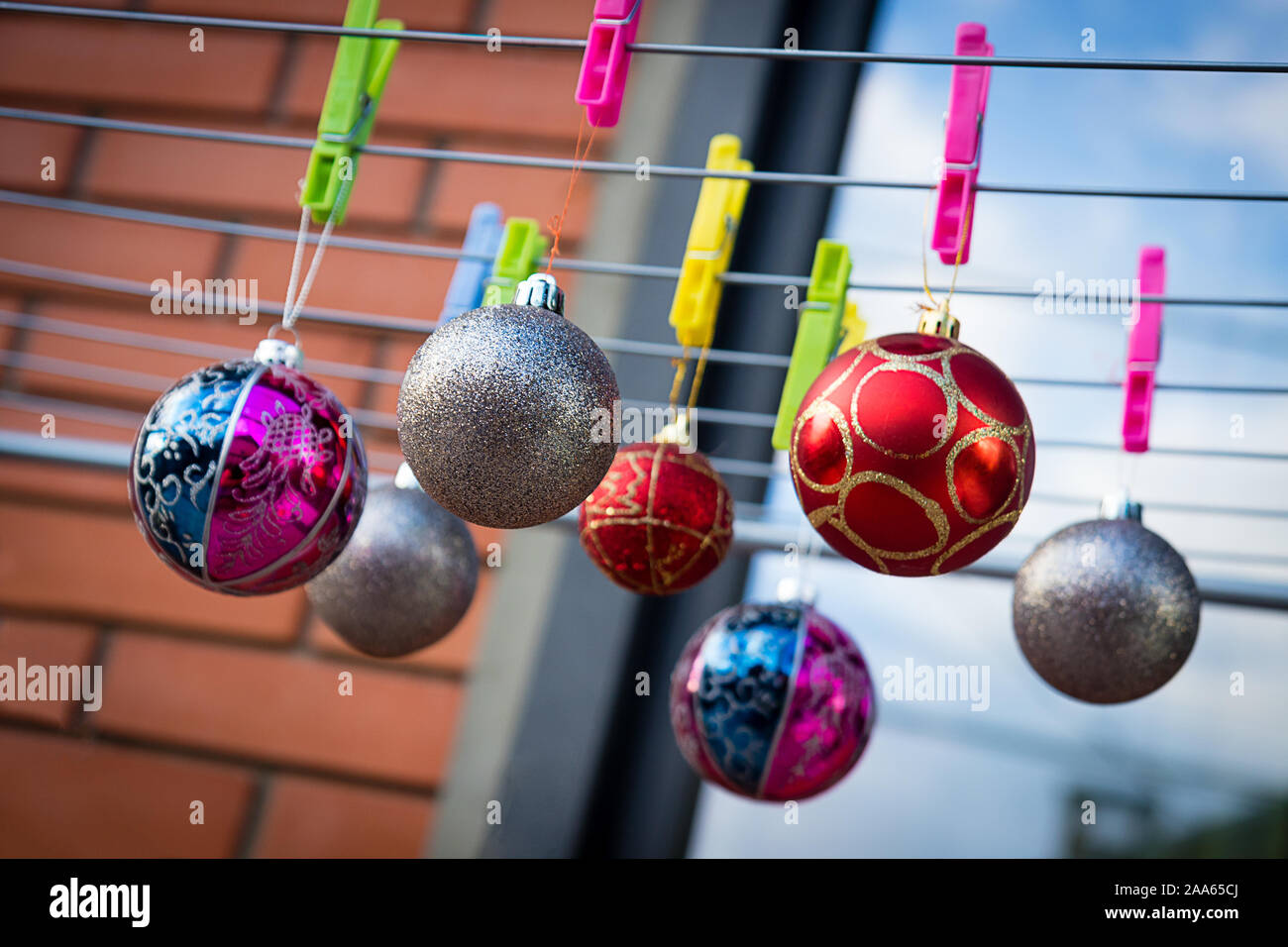 Weihnachtskugeln Ornamente hängen auf der Clips auf dem Wäscheständer. Weihnachten mit Hausarbeit. Stockfoto