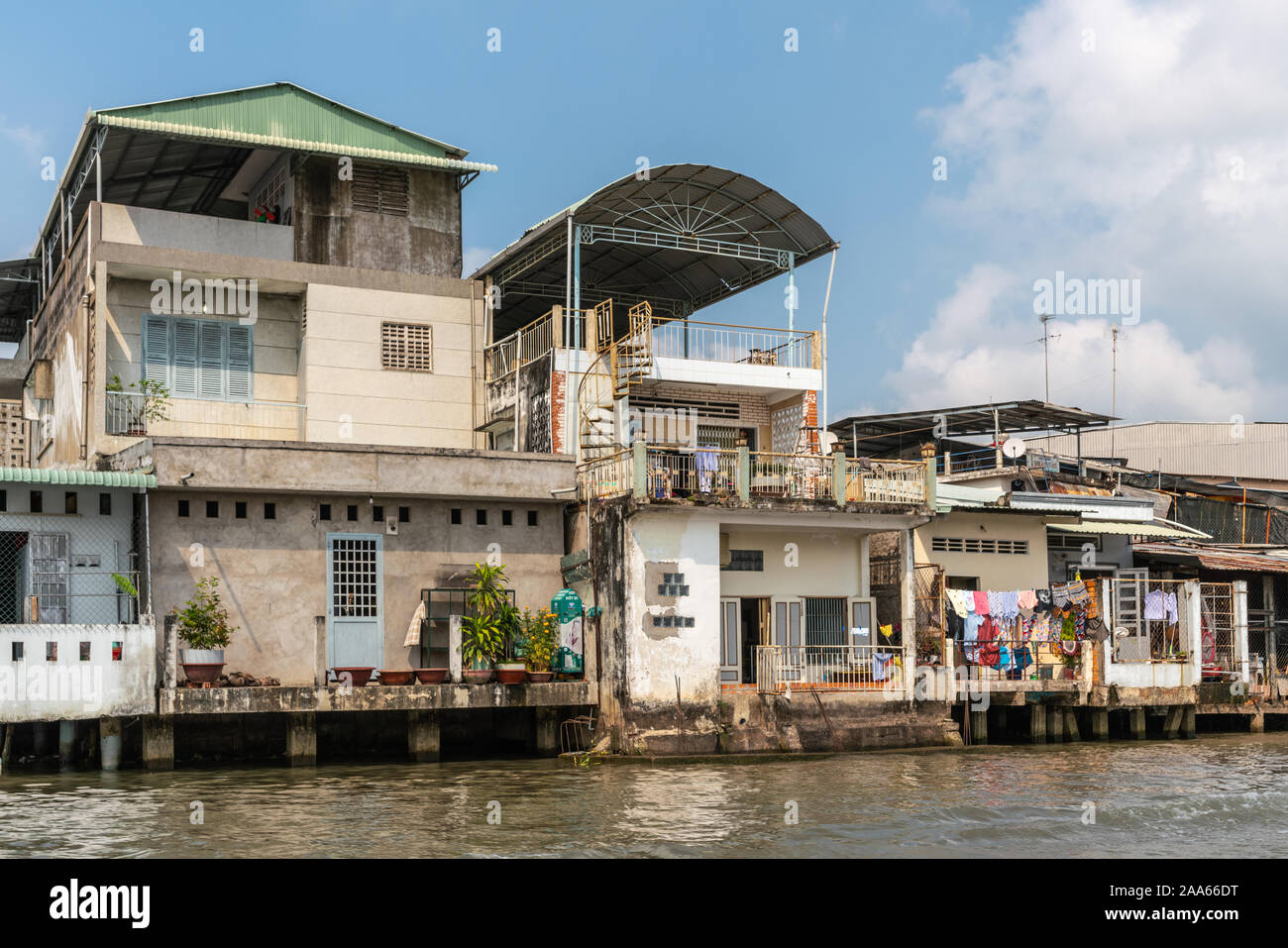 Cai, Mekong Delta, Vietnam - März 13, 2019: Entlang der Kinh 28 Kanal. 3-stöckiges, beige kommerzielle Wohnungen mit eigenem lebende Teile. Das Trocknen von Wäsche hinzufügen Stockfoto