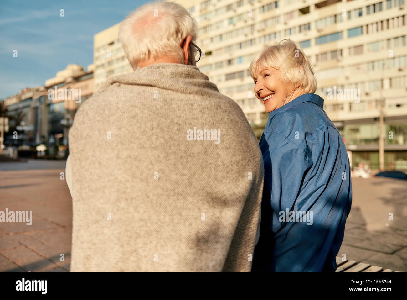 Was für ein schöner Tag! Rückansicht des Senior Paar in Freizeitkleidung auf der Bank sitzen zusammen und sprechen über etwas. Älterer Mann und Frau Stockfoto