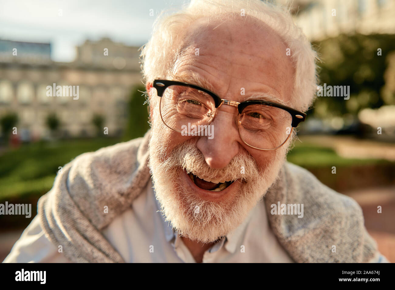 Nicht über älter zu machen. Portrait von gut aussehenden Bärtigen älteren Mann in Gläsern an Kamera schauen und lächeln beim Stehen im Freien an einem sonnigen d Stockfoto